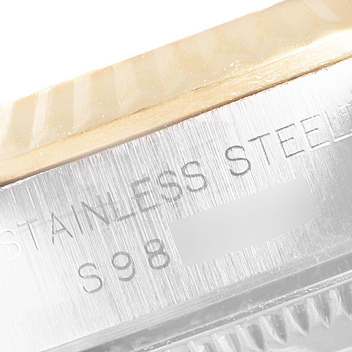 This close-up image shows the engraved stainless steel casing of a Rolex Oyster Perpetual 67193 Women's Steel and Gold (two tone) Grey Dial 67193 Women's Steel and Gold (two tone) Grey Dial watch.