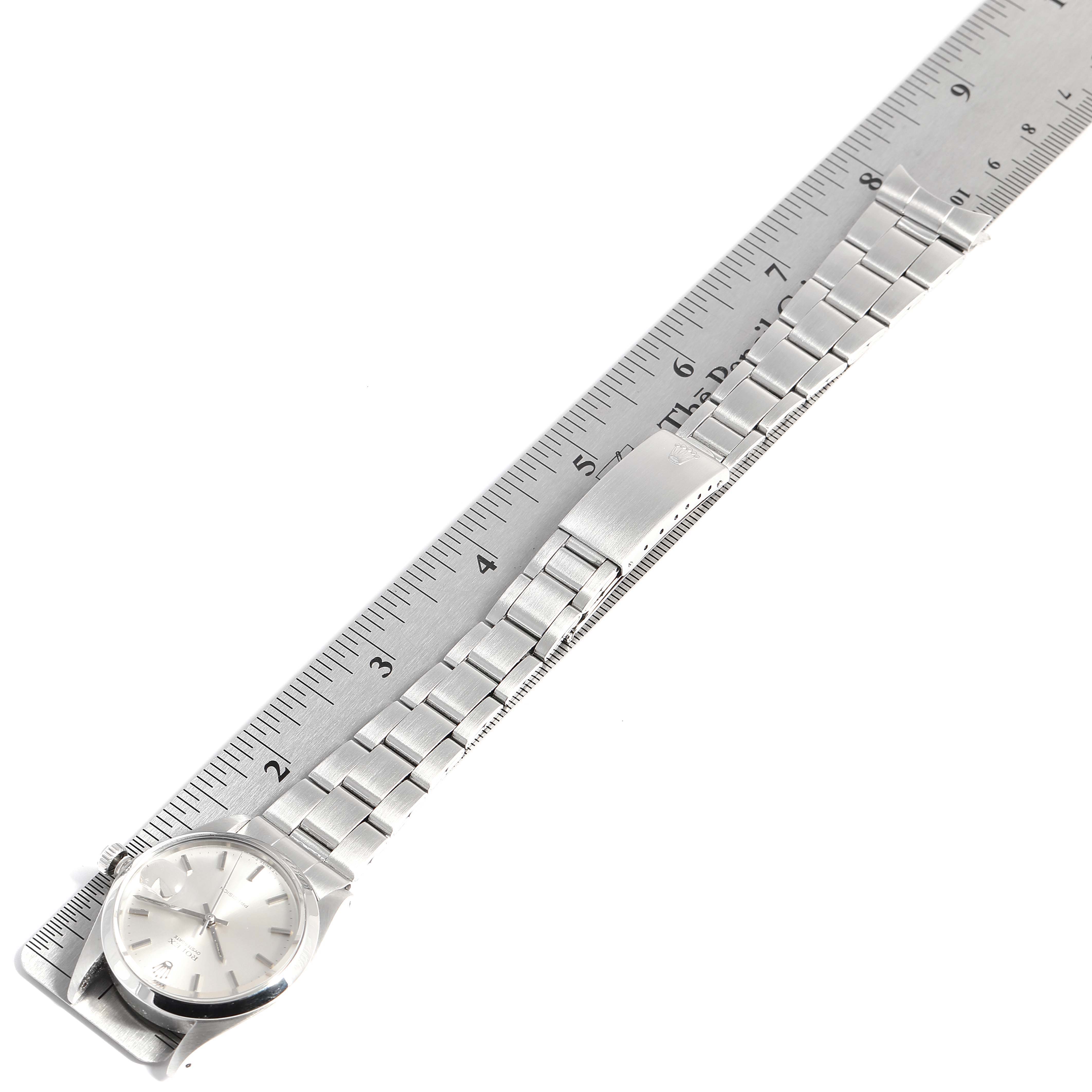 The image shows a Vintage Collection Rolex watch with its band aligned along a ruler, displaying the watch face, crown, and metal bracelet.