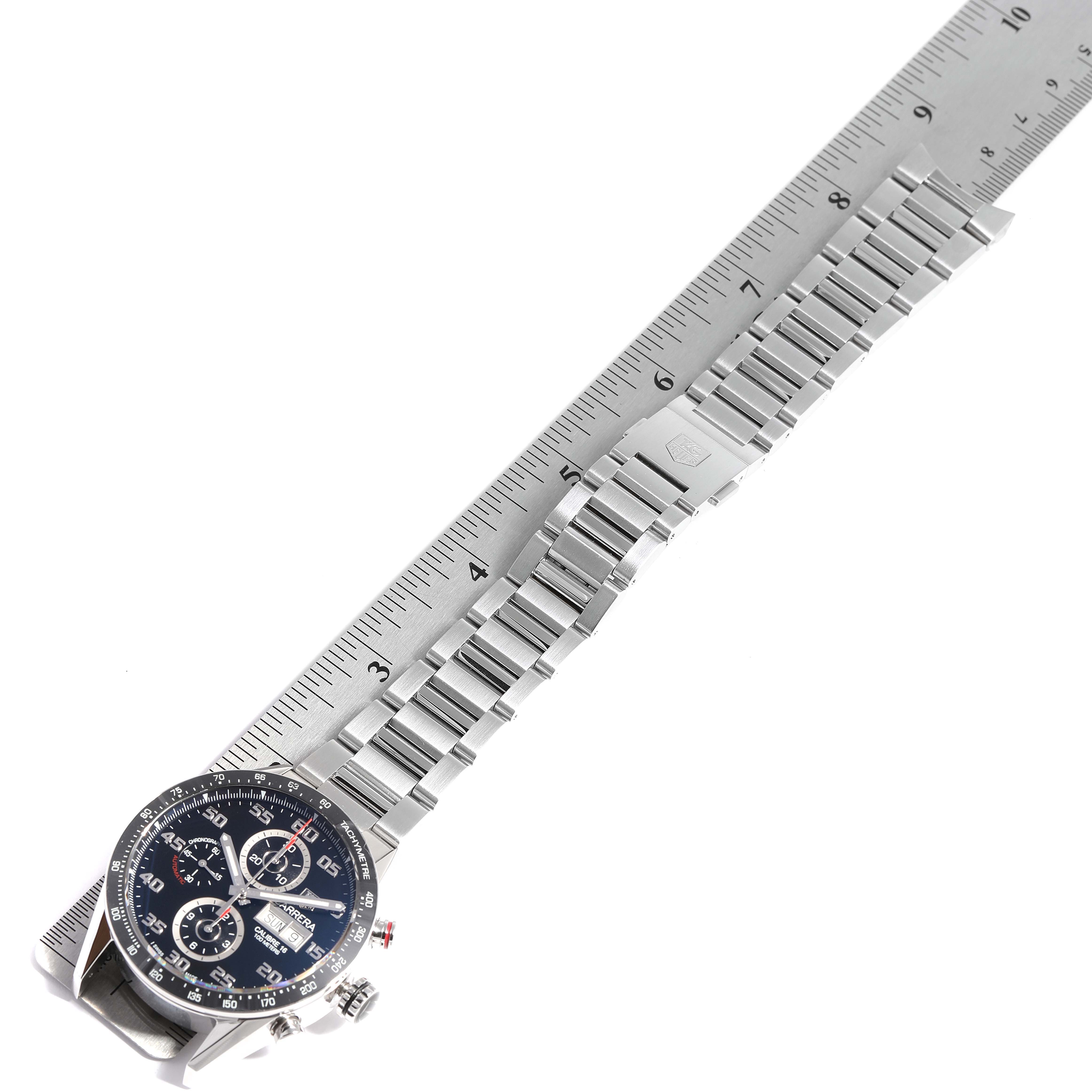 The image shows the face and bracelet of a Tag Heuer Carrera CV2A1R.BA0799 Men
s Stainless Steel Black Dial CV2A1R.BA0799 Men
s Stainless Steel Black Dial watch placed alongside a ruler for measurement.