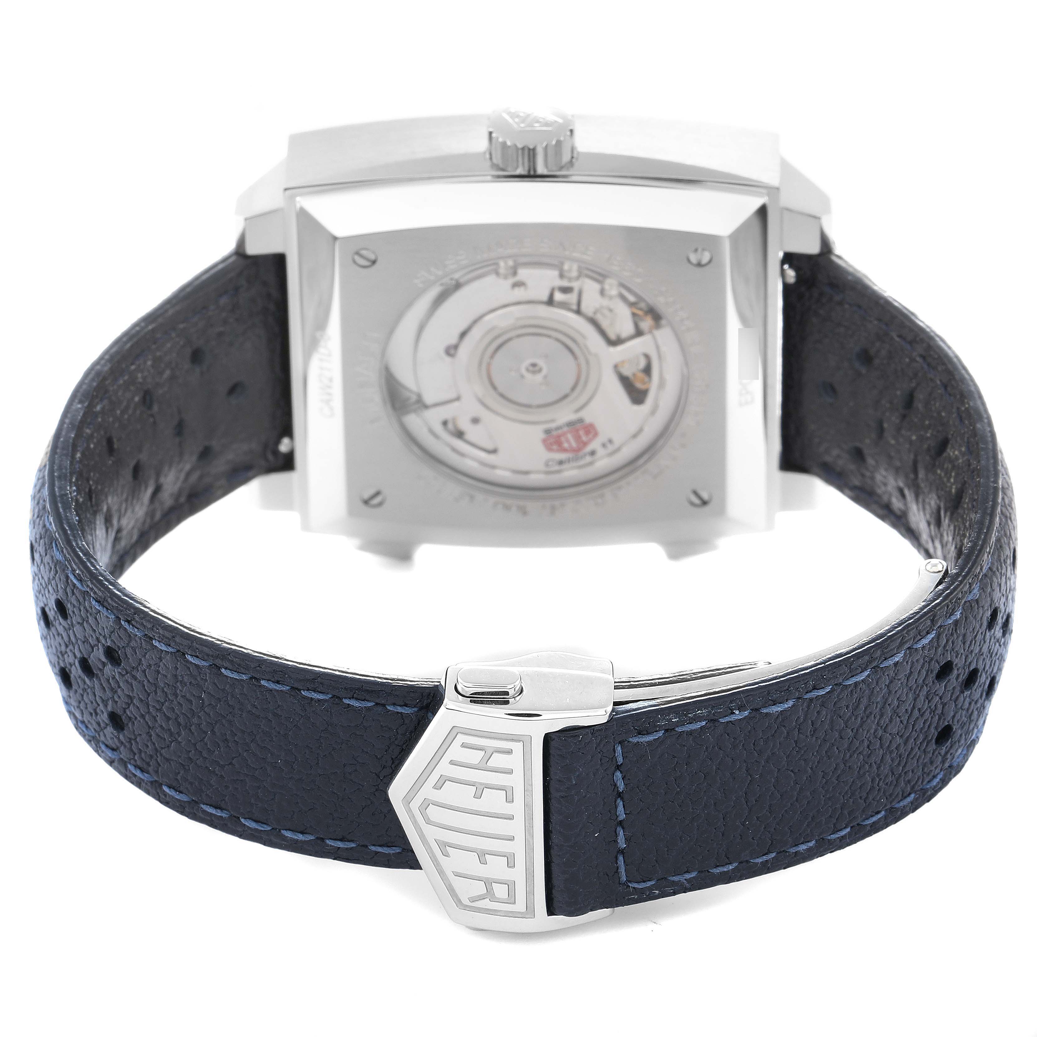 The image shows the back of a Tag Heuer Monaco CAW211D Men
s Stainless Steel Blue Dial watch, highlighting the movement and leather strap with branding.