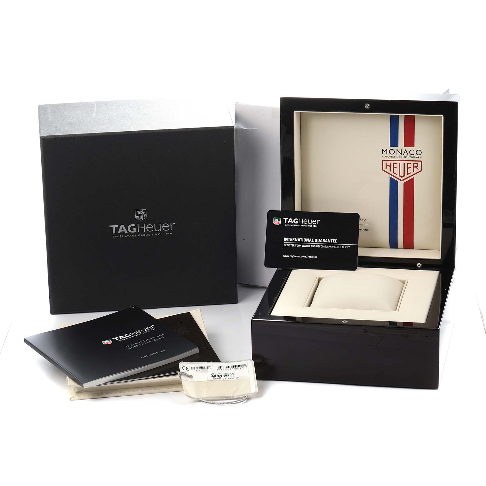 The image shows a TAG Heuer Monaco watch box, guarantee card, and manuals at a slight angle.