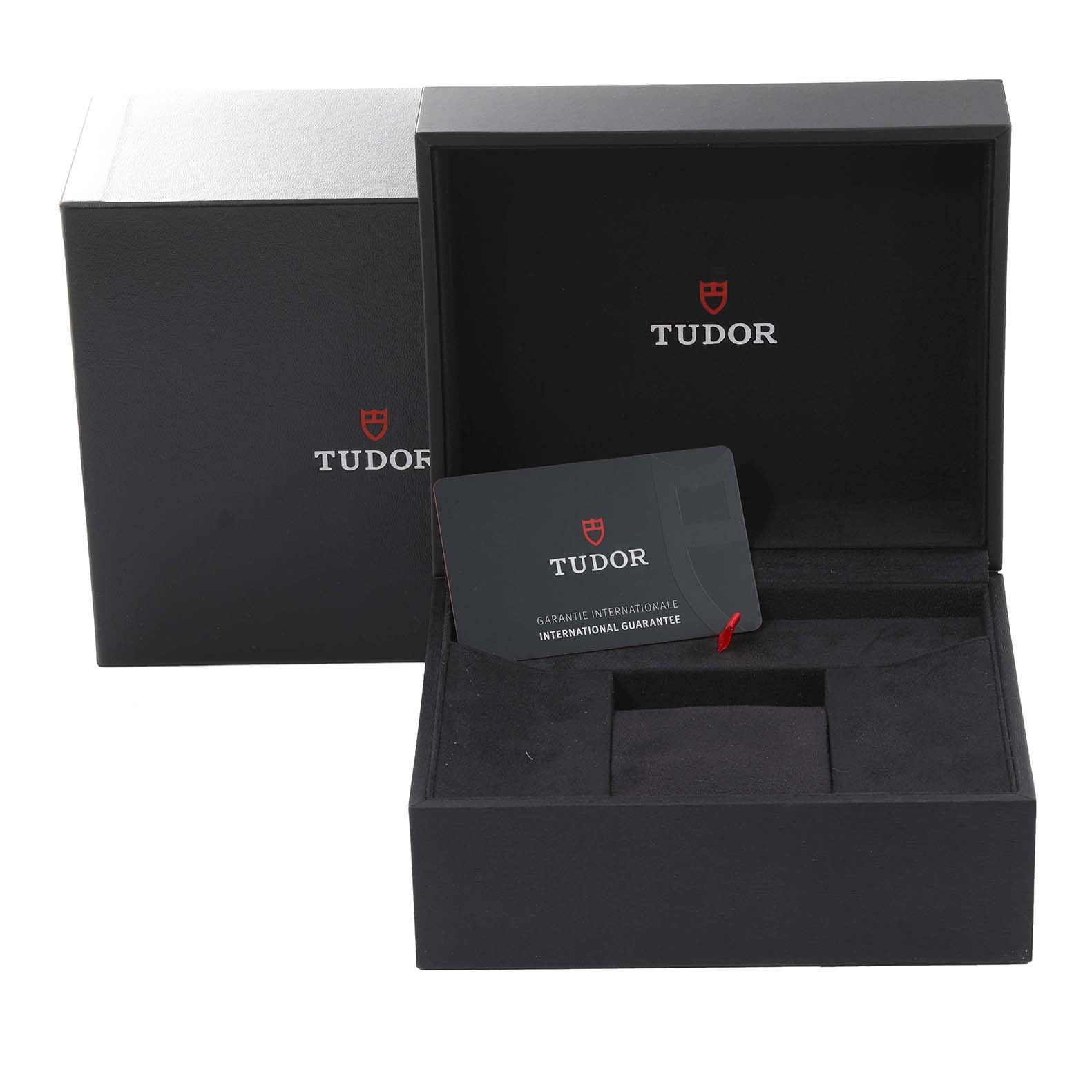 This image shows the open box of the Tudor Heritage Black Bay 79360N-002 Men's Stainless Steel White Dial 79360N-002 Men's Stainless Steel White Dial watch with an international guarantee card inside.