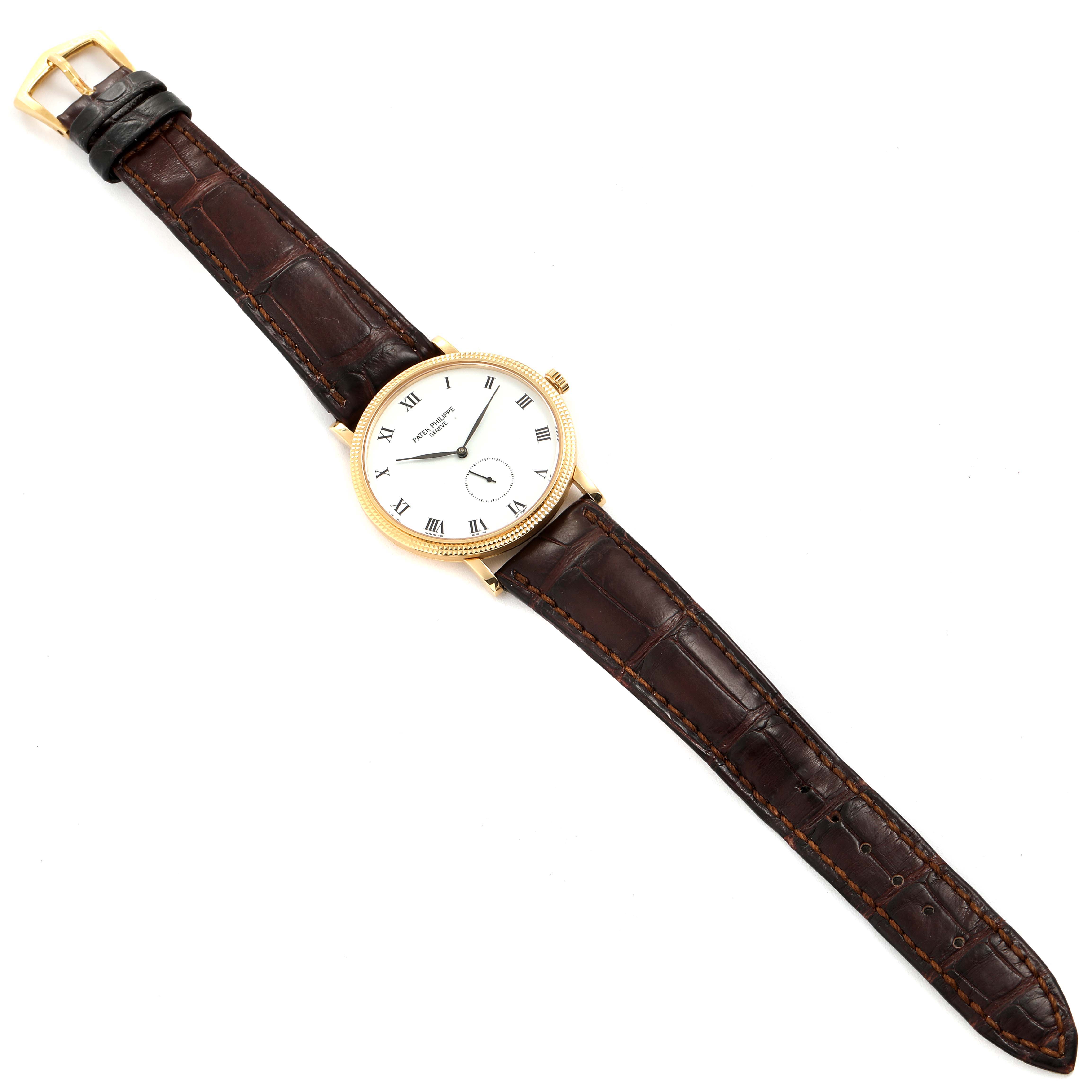 The image shows an overhead view of the Calatrava model by Patek Philippe, displaying the entire watch, including its face, straps, and buckle.