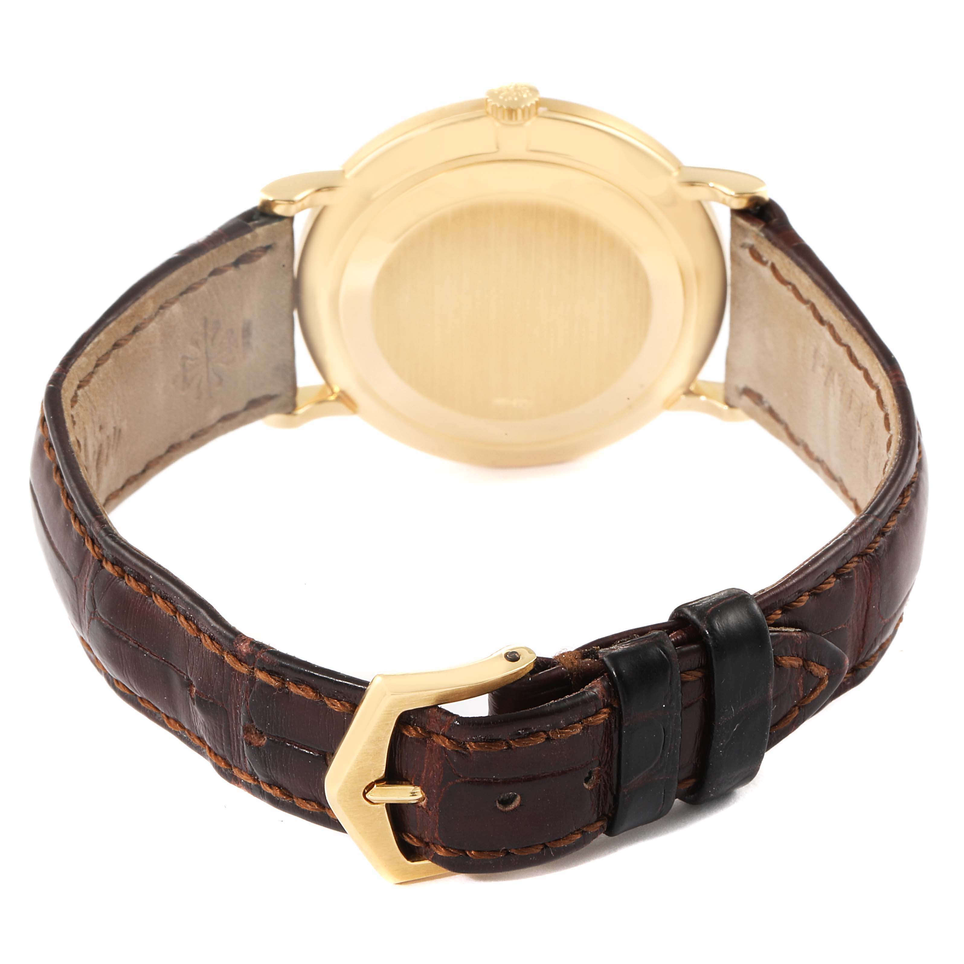 The image shows the backside and the leather strap of a Patek Philippe Calatrava 3919 Men's Yellow Gold White Dial 3919 Men's Yellow Gold White Dial watch placed at an angle.