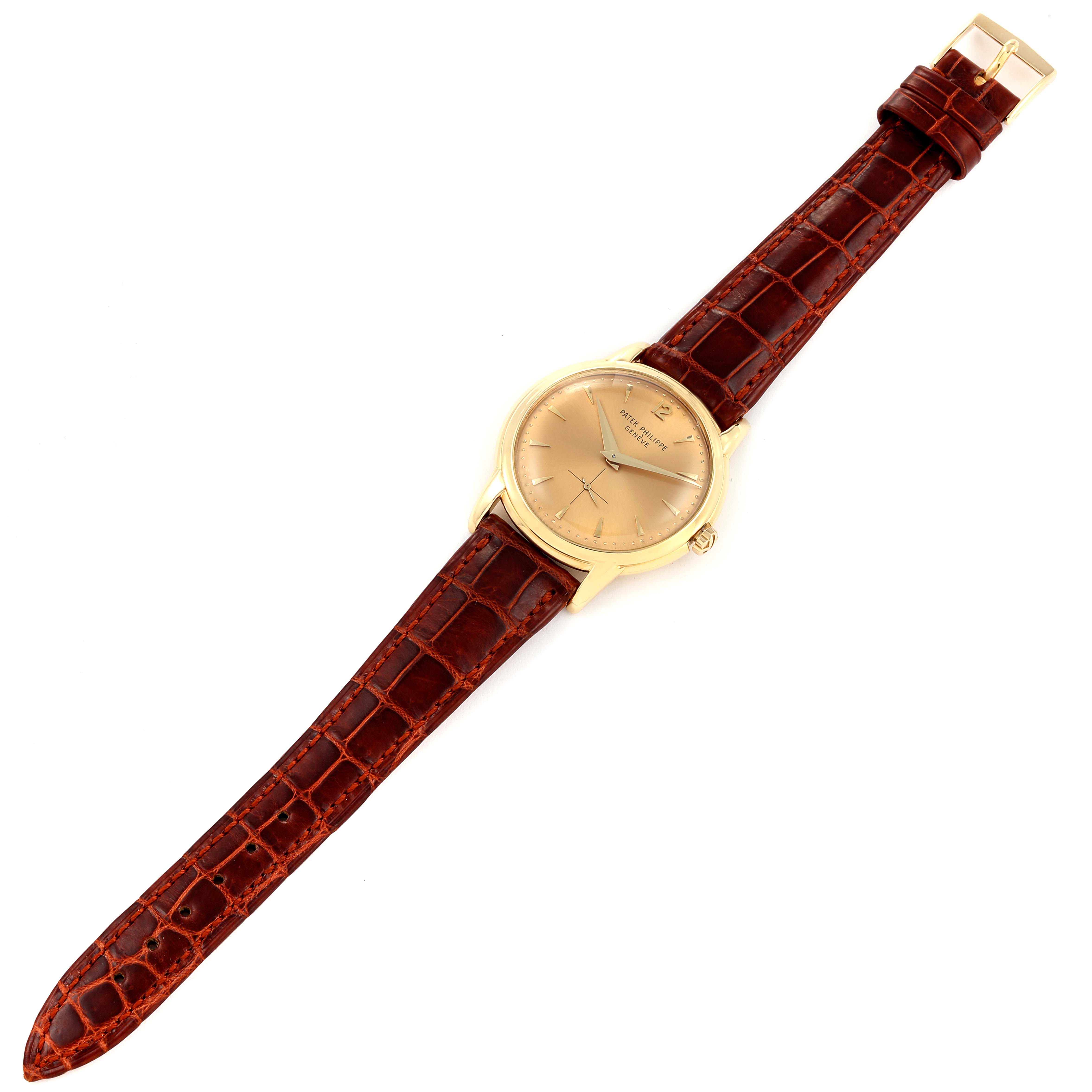 The image shows a Patek Philippe Vintage watch laid flat, displaying its gold face, brown leather strap, and buckle clasp.