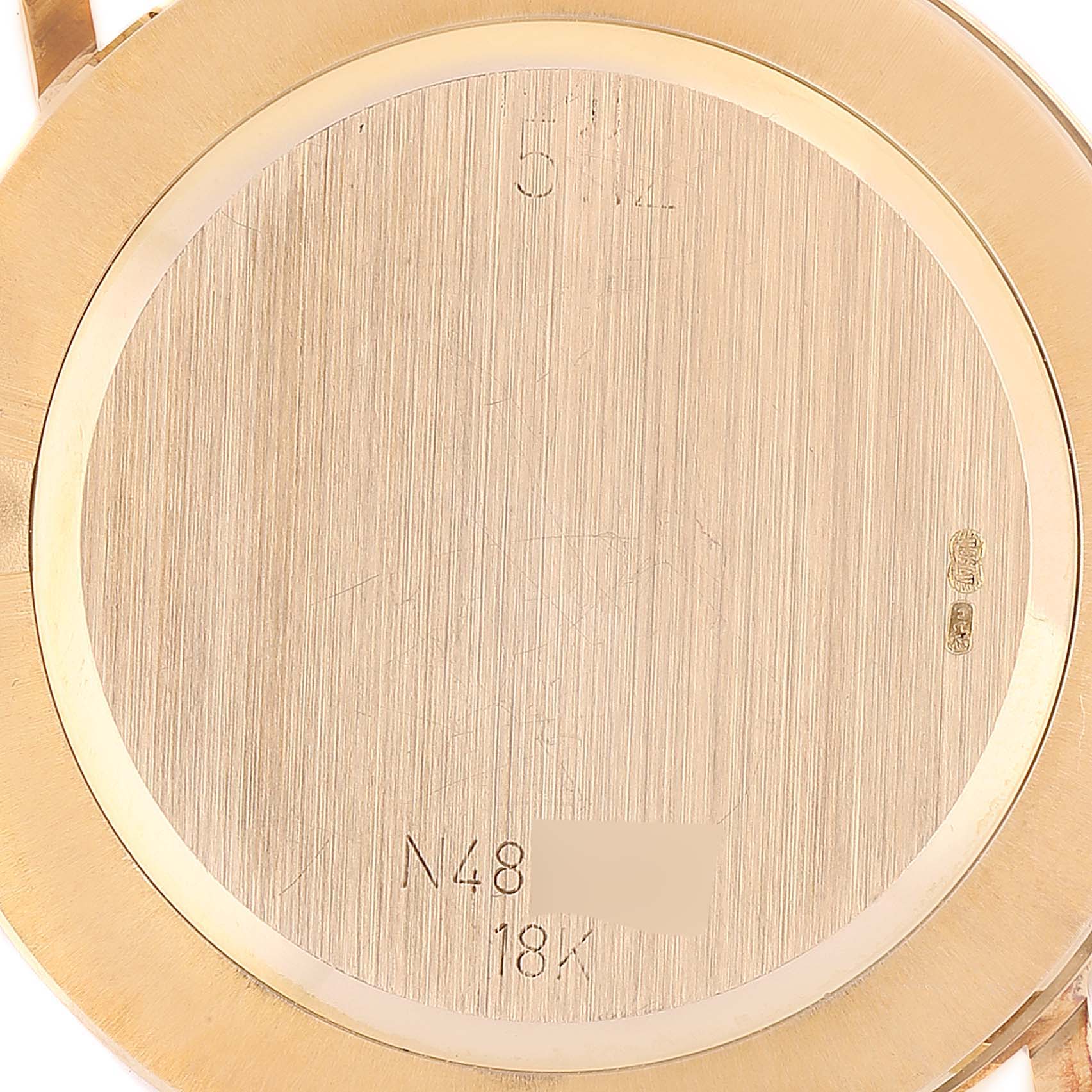 The image shows the gold case back of a Rolex Cellini 5112 Men's Yellow Gold Champagne Dial 5112 Men's Yellow Gold Champagne Dial watch from a close-up angle.