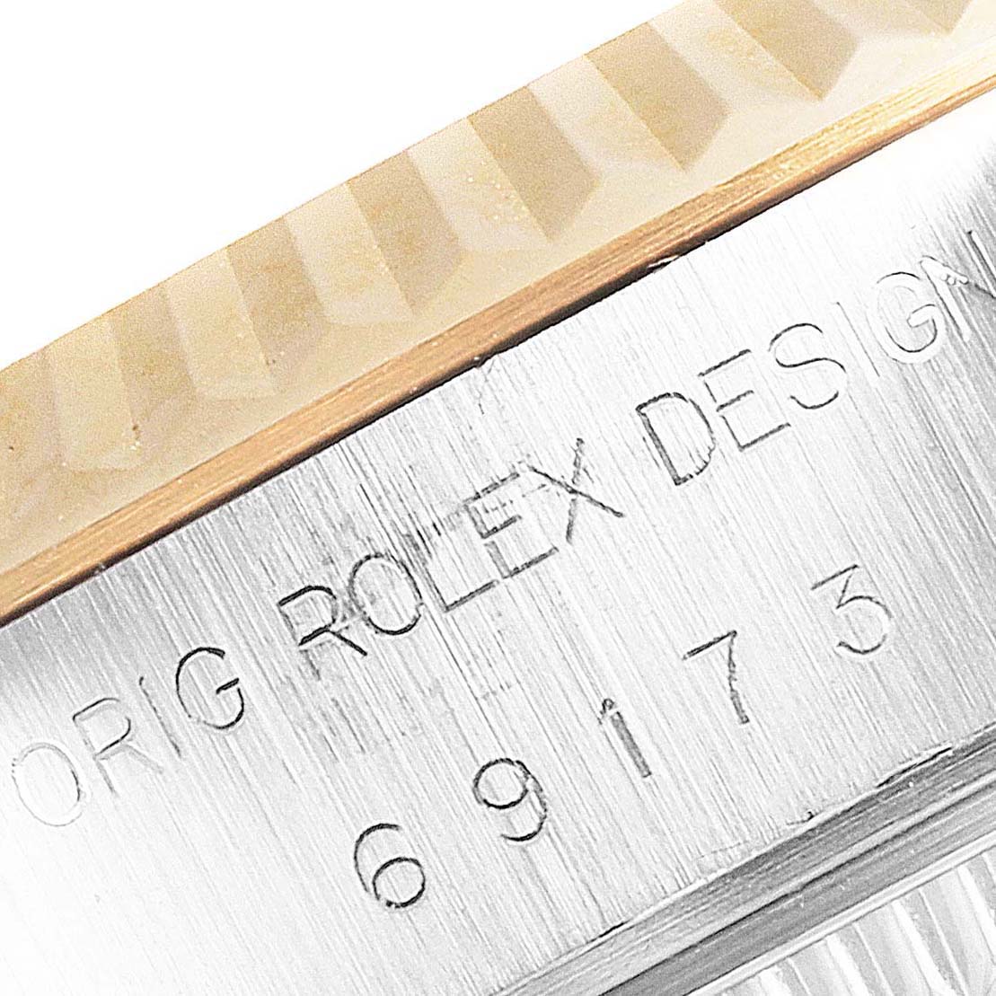 The image shows a macro view of the bezel and engraved text on the side of the Rolex Datejust 69173 Women
s Steel and Gold (two tone) Champagne Dial 69173 Women
s Steel and Gold (two tone) Champagne Dial watch.