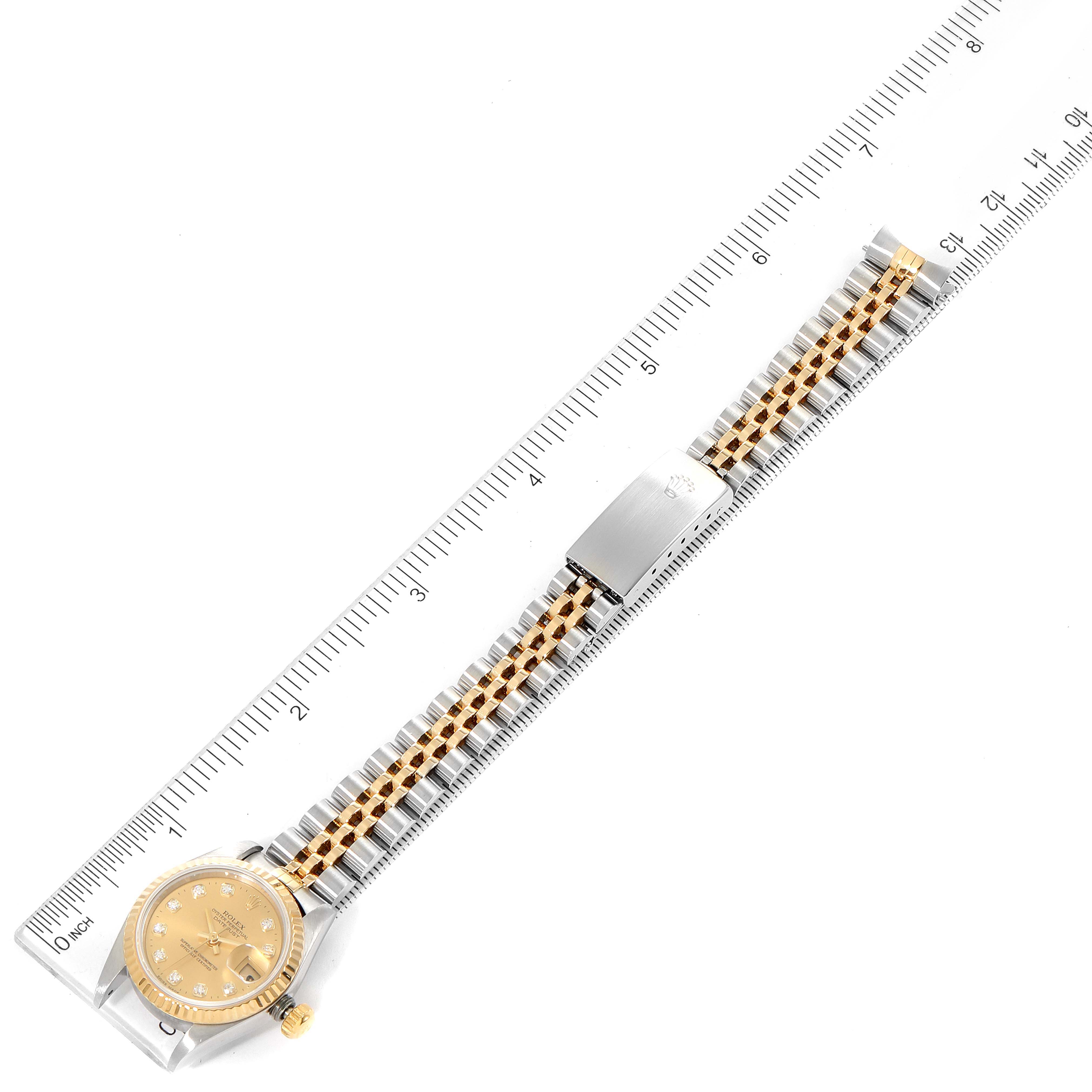 The Rolex Datejust 69173 Women
s Steel and Gold (two tone) Champagne Dial 69173 Women
s Steel and Gold (two tone) Champagne Dial watch is shown from a top-down angle, displaying the face, bracelet, and clasp, aligned with a ruler.