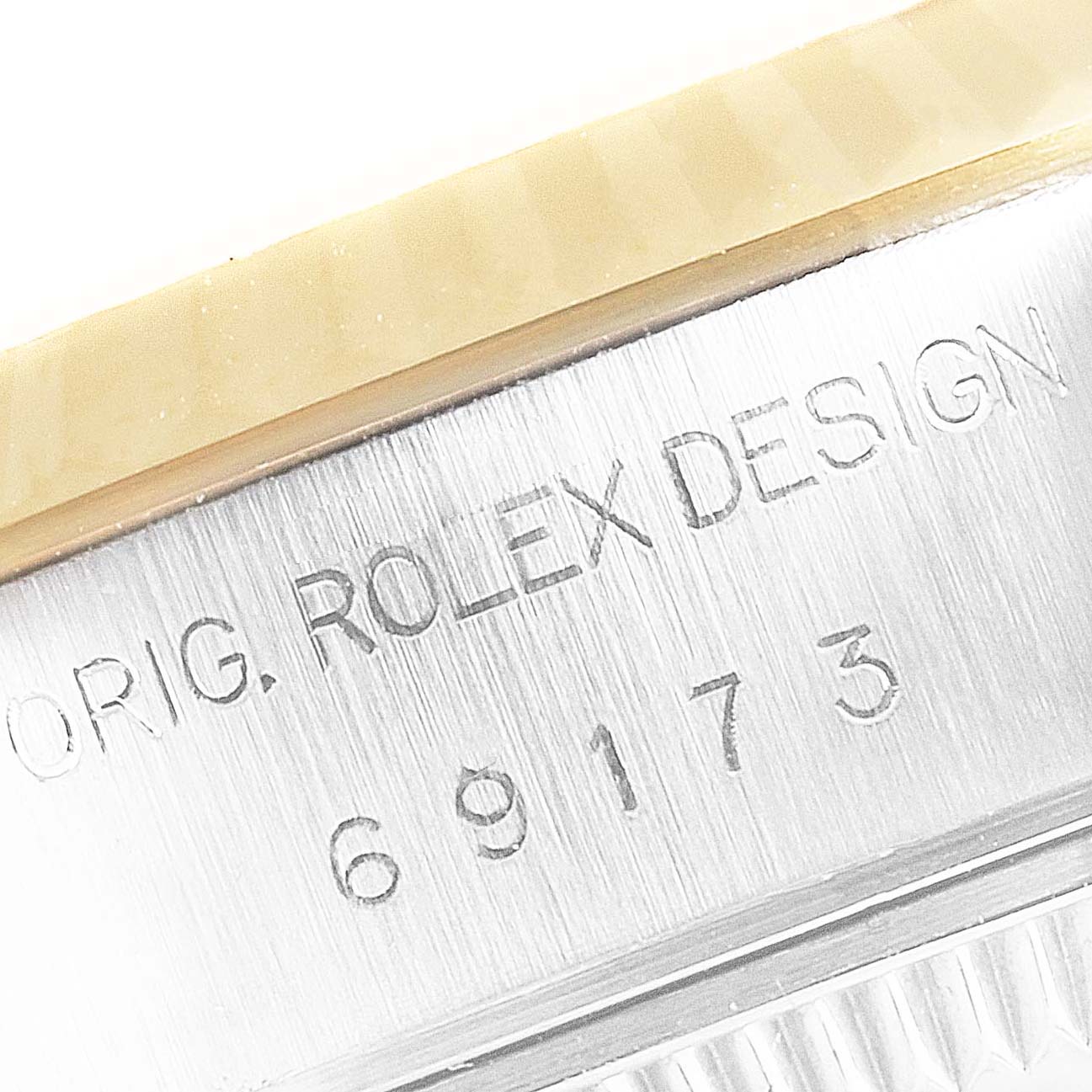 The image shows a close-up of the Rolex Datejust 69173 Women
s Steel and Gold (two tone) Champagne Dial 69173 Women
s Steel and Gold (two tone) Champagne Dial model
s case side, featuring the engraved text and part of the bezel.