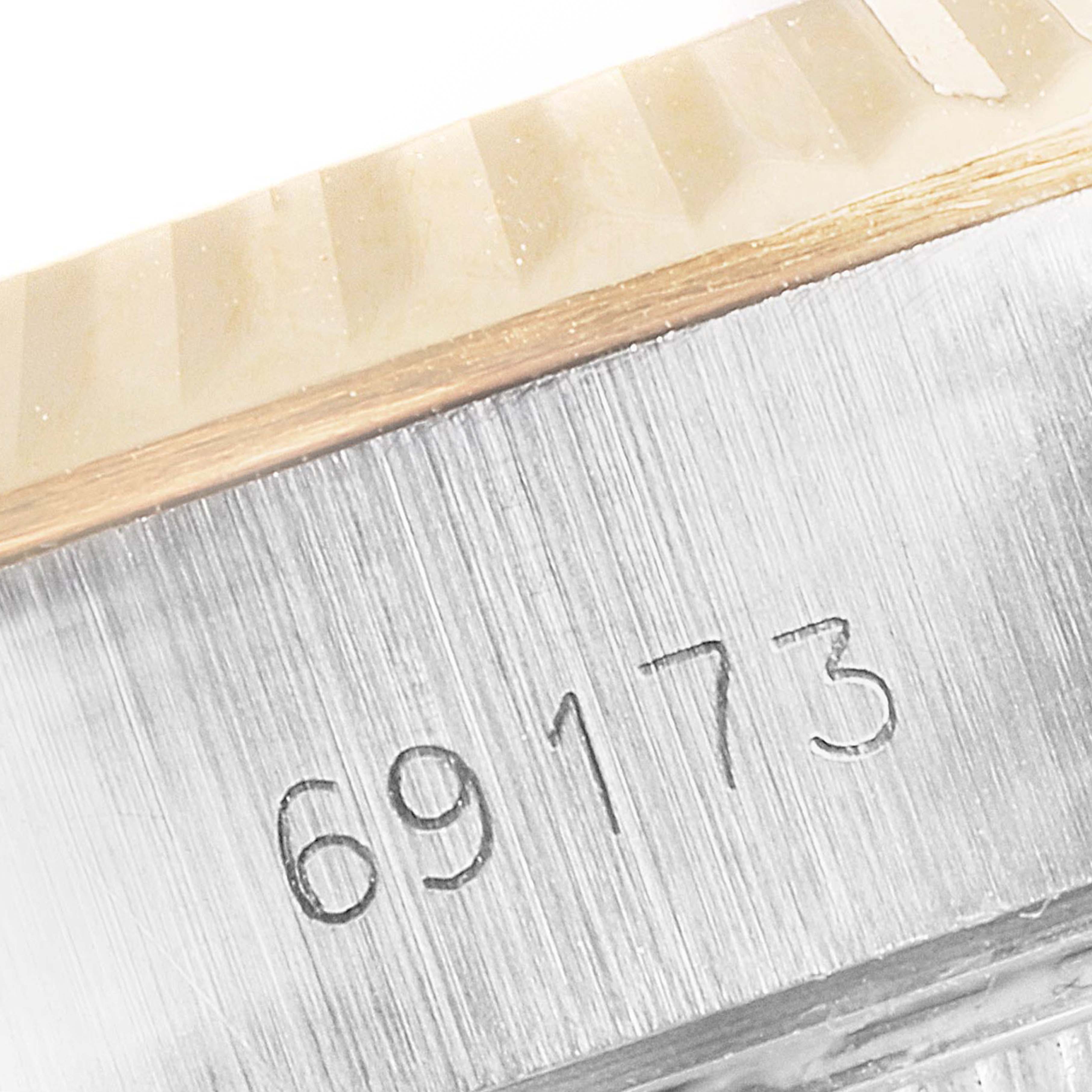 This image shows a close-up of the serial number engraving and the fluted bezel of a Rolex Datejust 69173 Women
s Steel and Gold (two tone) Champagne Dial 69173 Women
s Steel and Gold (two tone) Champagne Dial watch model 69173.
