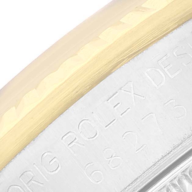 A close-up image of the bezel and case edge of a Rolex Mid-Size 68273 Women's Steel and Gold (two tone) Silver Dial 68273 Women's Steel and Gold (two tone) Silver Dial watch, partially showing the engraved text.