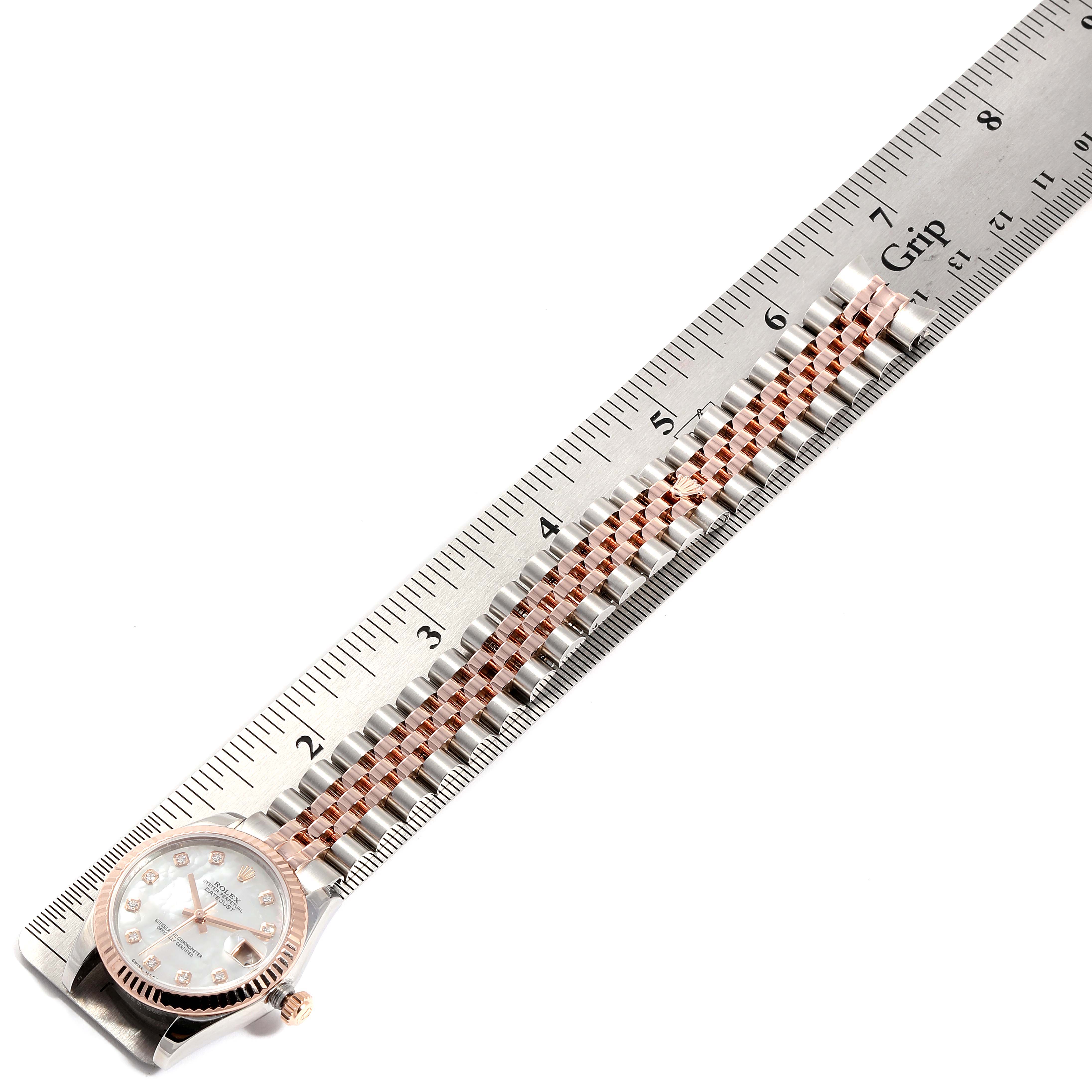 The image shows a Rolex Mid-Size 178271 Women
s Steel and Gold (two tone) Mother of Pearl Dial 178271 Women
s Steel and Gold (two tone) Mother of Pearl Dial watch at a top-down angle, highlighting the face, bezel, and parts of the bracelet, measured against a ruler.