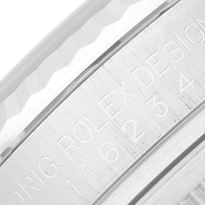 This image shows an angled close-up of the engraved inner bezel of a Rolex Datejust 116234 Men's Stainless Steel White Dial 116234 Men's Stainless Steel White Dial watch.