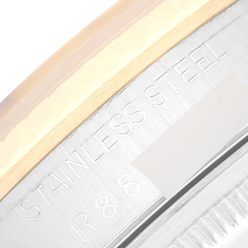 This close-up image shows part of the stainless steel bezel and engraved text on the Datejust model by Rolex.