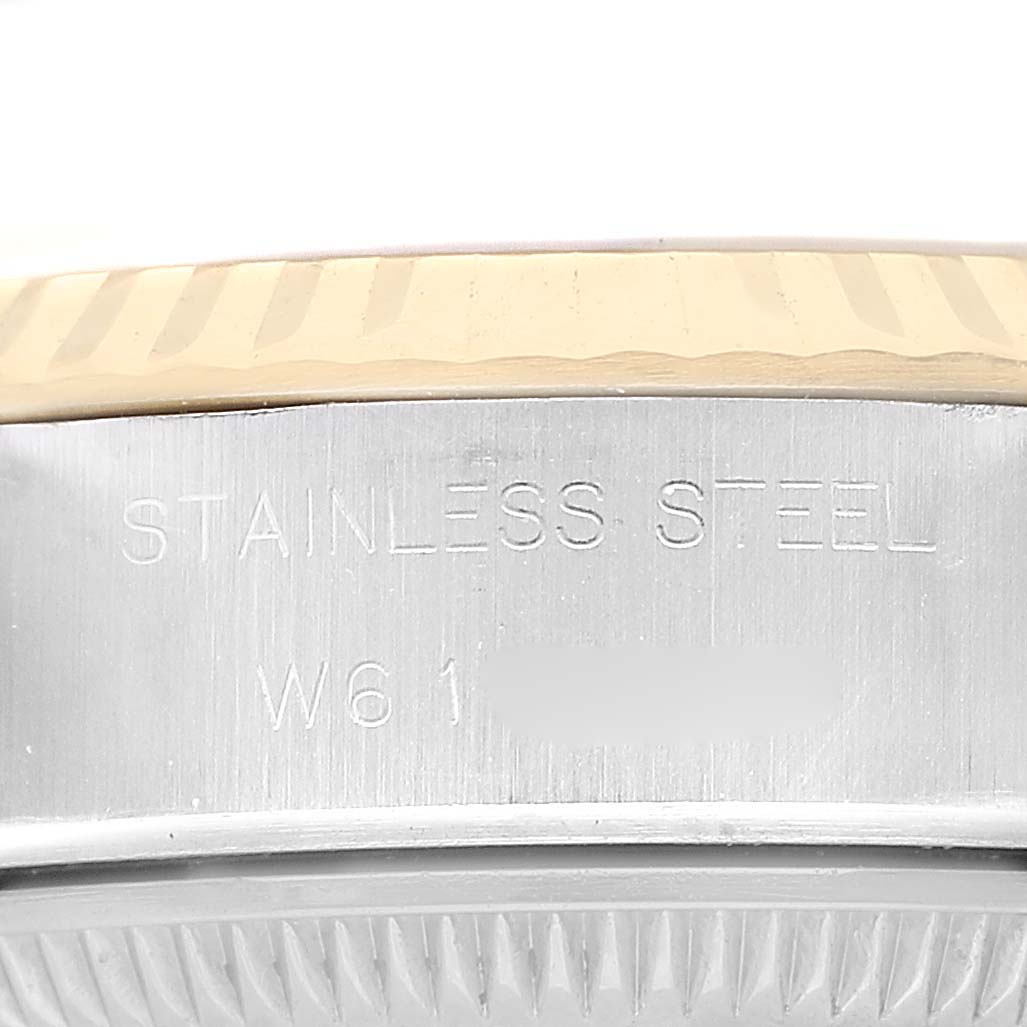 The image shows a side view of the Rolex Datejust 69173 Women's Steel and Gold (two tone) White Dial's stainless steel case with engraved text and part of the fluted bezel.