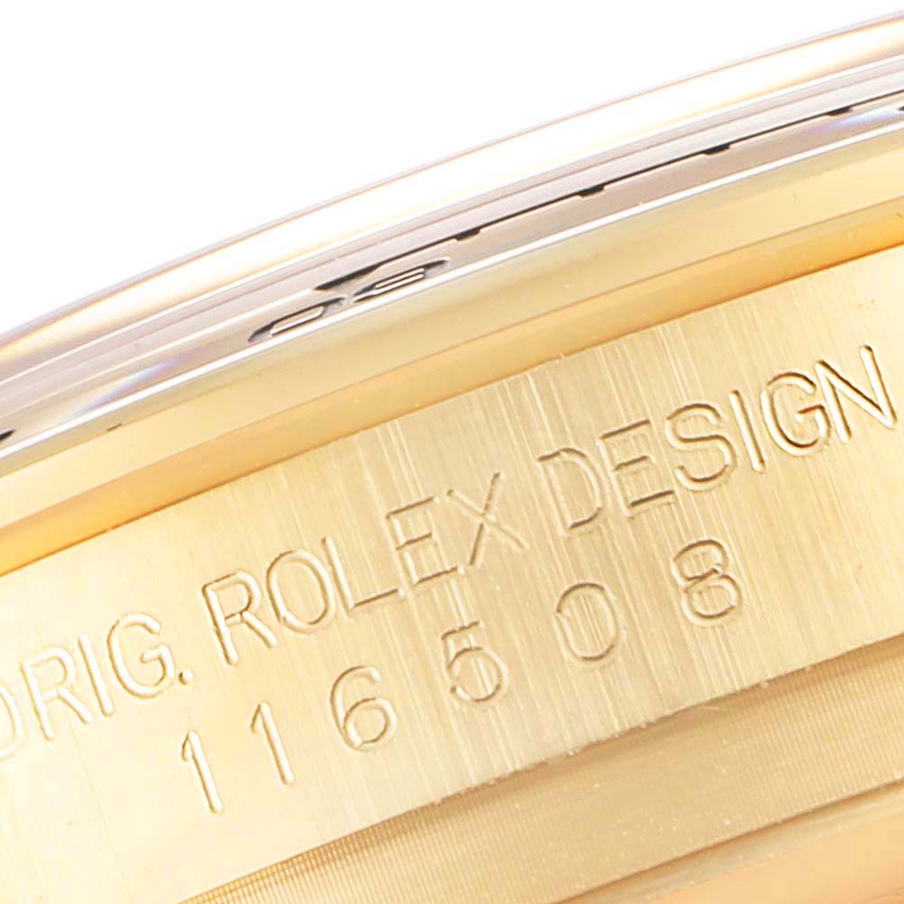 This close-up of a Rolex Daytona 116508 Men's Yellow Gold Black Dial 116508 Men's Yellow Gold Black Dial watch showcases the engraved serial number and "Rolex Design" on the case edge.