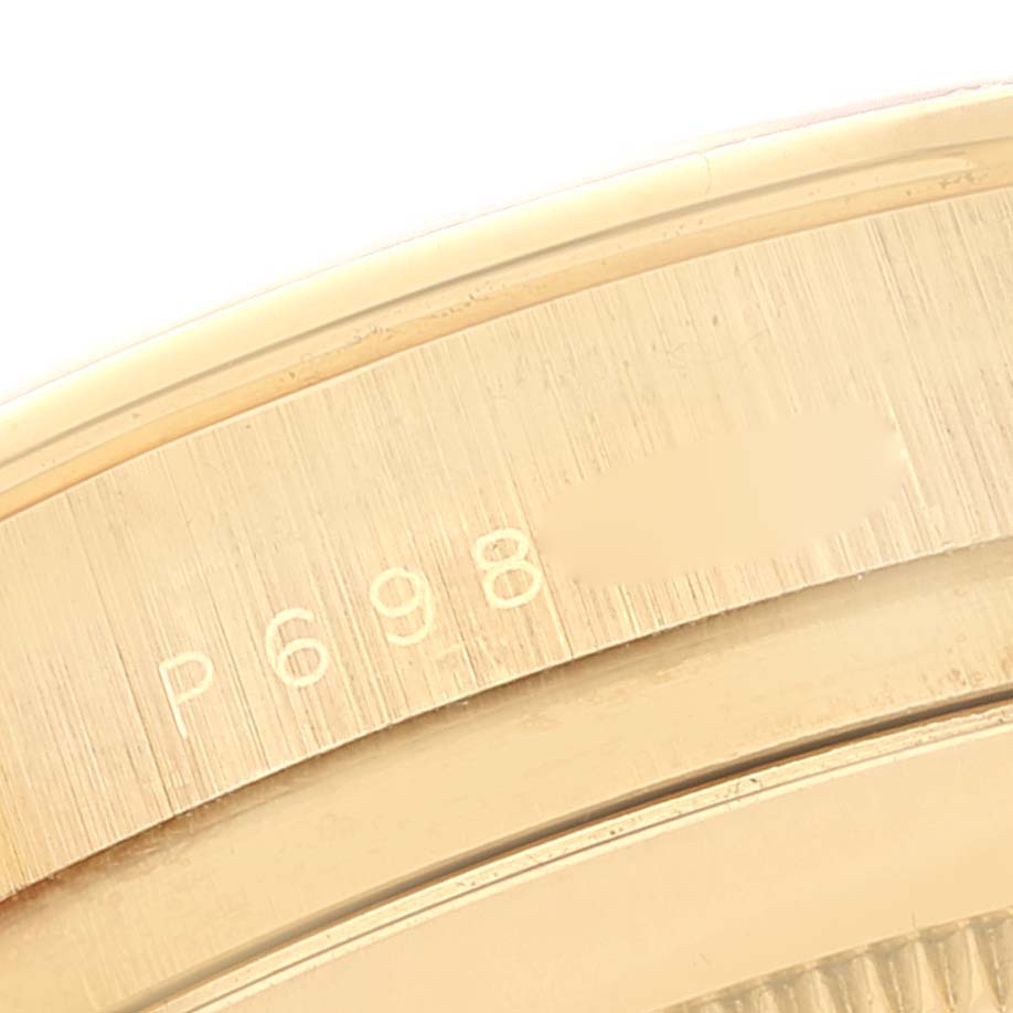 This image shows a close-up of the engraved serial number on the side of the case of a Rolex Daytona 116528 Men's Yellow Gold Champagne Dial 116528 Men's Yellow Gold Champagne Dial watch.