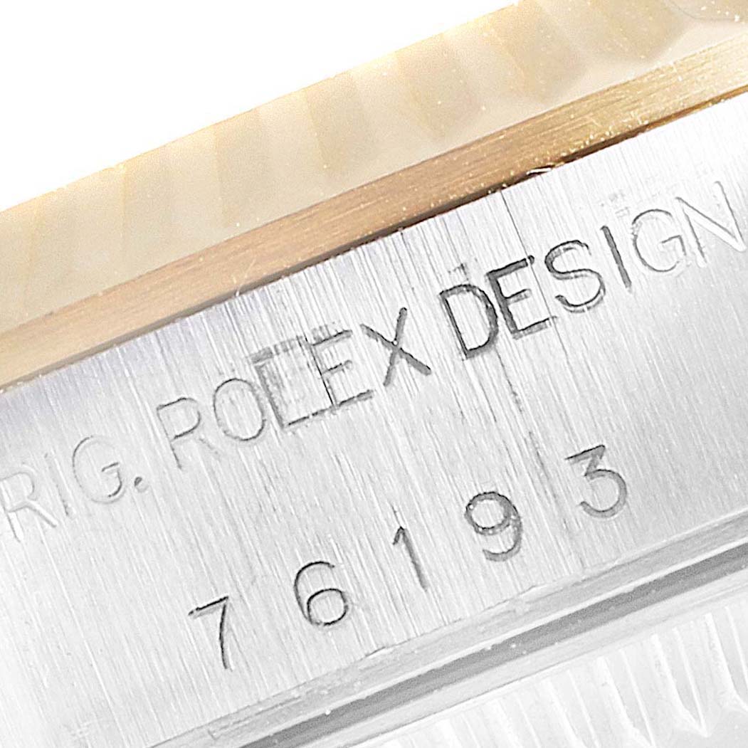 This close-up image shows the model number and "ROLEX DESIGN" engraving on the side of a Rolex Oyster Perpetual 76193 Women
s Steel and Gold (two tone) Champagne Dial 76193 Women
s Steel and Gold (two tone) Champagne Dial watch case.