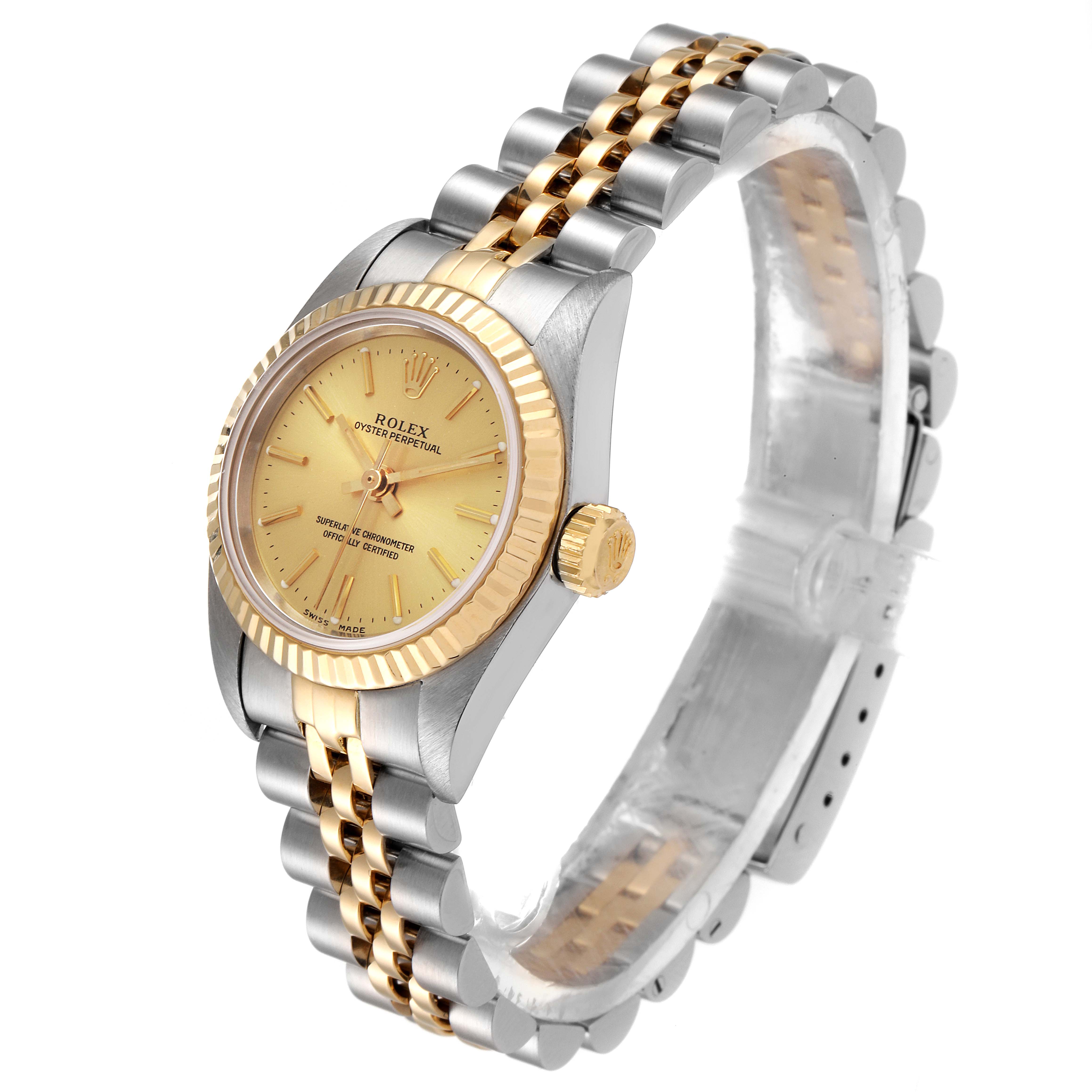 The image shows a side angle of a Rolex Oyster Perpetual 76193 Women
s Steel and Gold (two tone) Champagne Dial 76193 Women
s Steel and Gold (two tone) Champagne Dial, highlighting its two-tone bracelet and gold bezel.