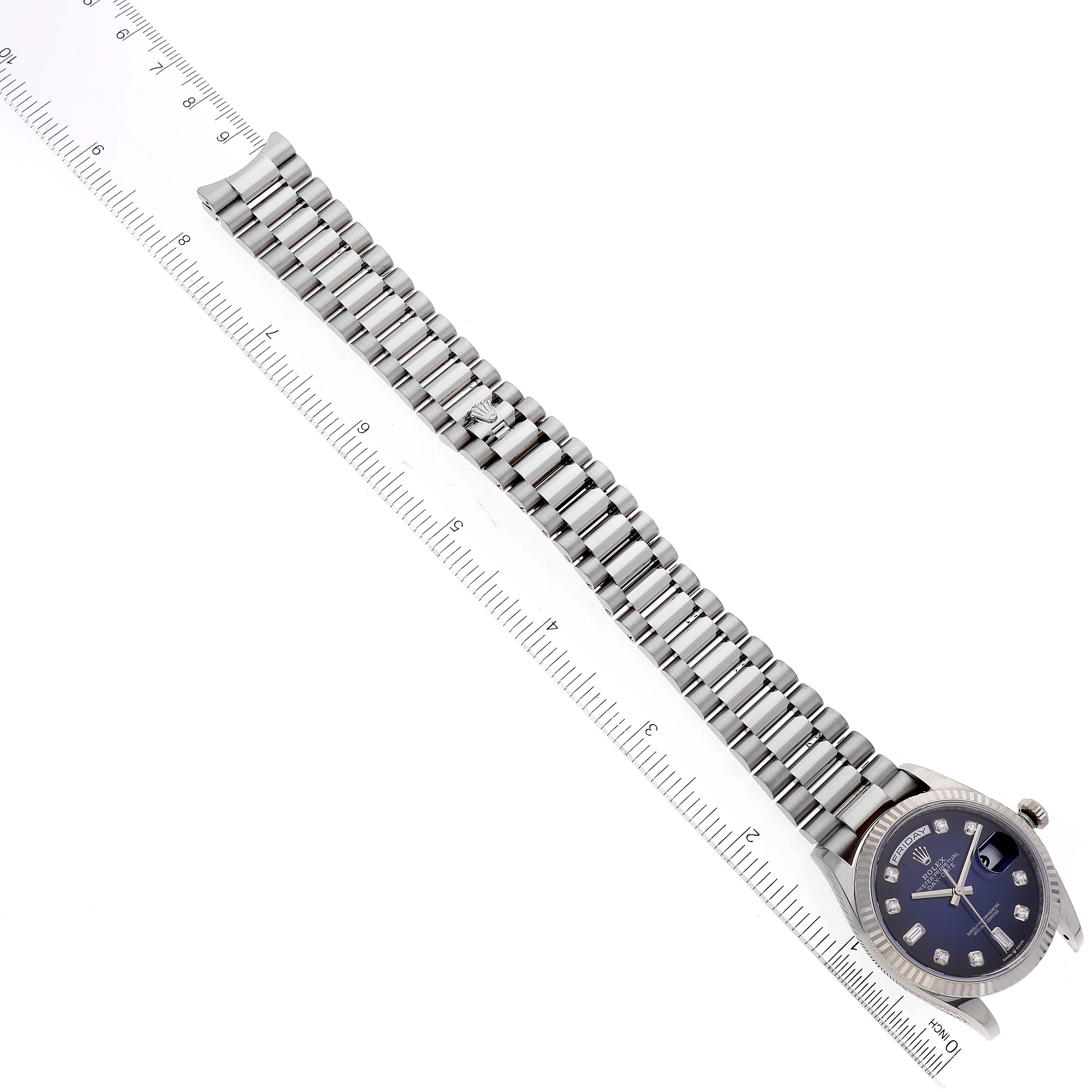 This image shows the face and bracelet of the Rolex President 128239 Men's White Gold Blue Dial 128239 Men's White Gold Blue Dial watch model, laid next to a ruler for scale.