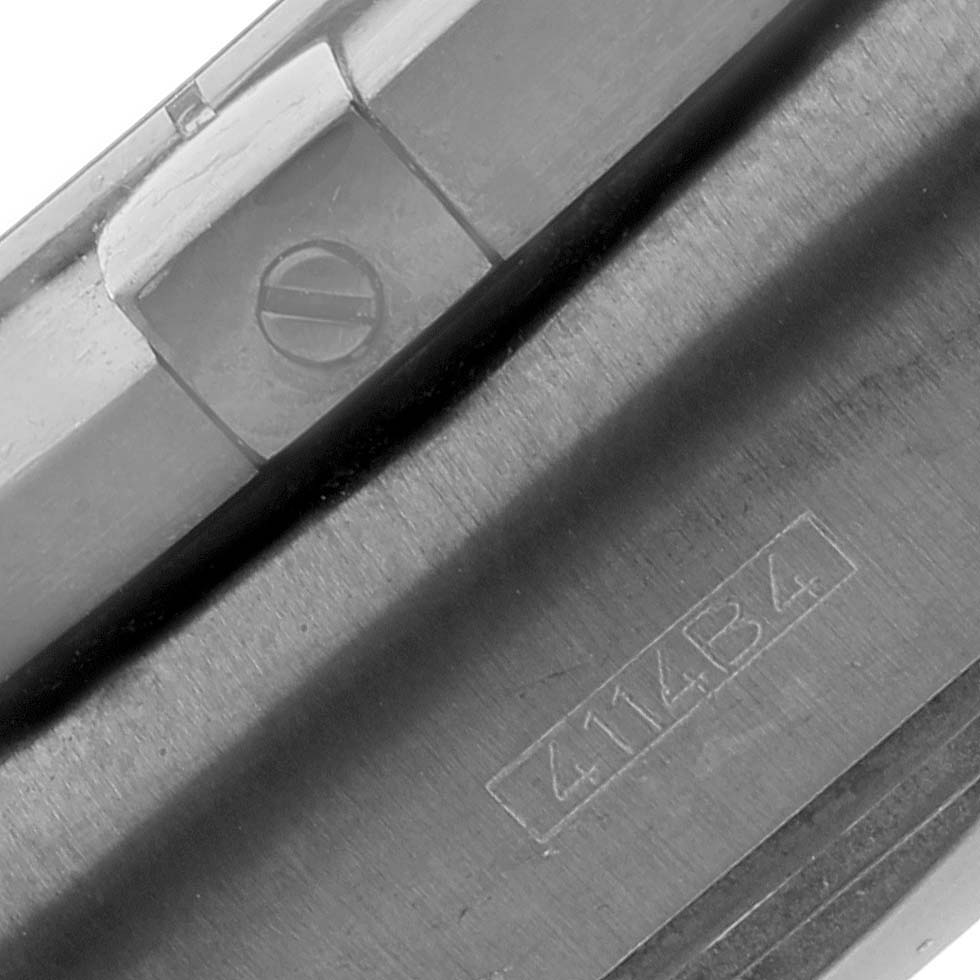 This image shows a close-up of a portion of the Breitling Chronomat MB0111 Men's Stainless Steel Black Dial MB0111 Men's Stainless Steel Black Dial watch case, highlighting the bezel and engraved serial number.