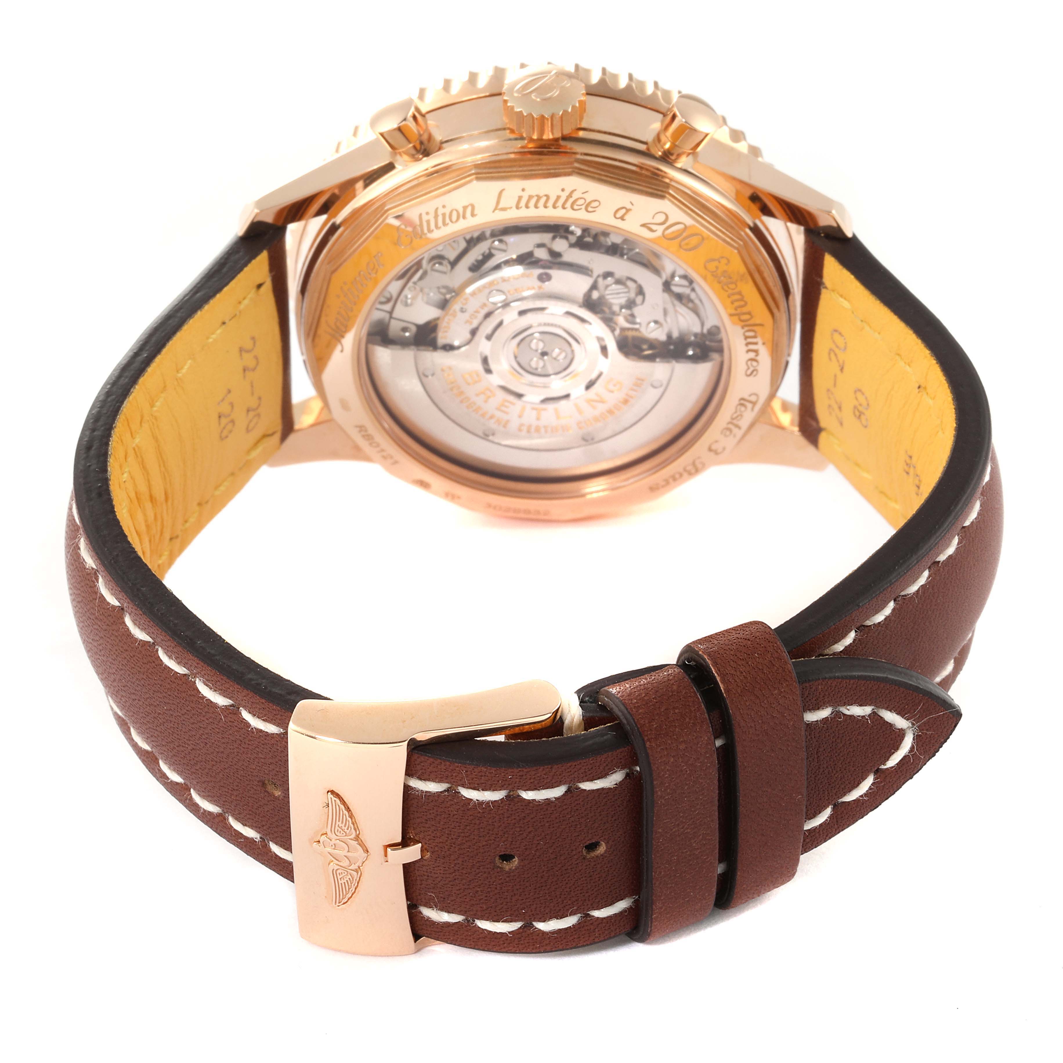 The image shows the back view of a Breitling Navitimer RB0121 Men's Rose Gold Black Dial RB0121 Men's Rose Gold Black Dial watch, highlighting its movement and brown leather strap with a deployment clasp.
