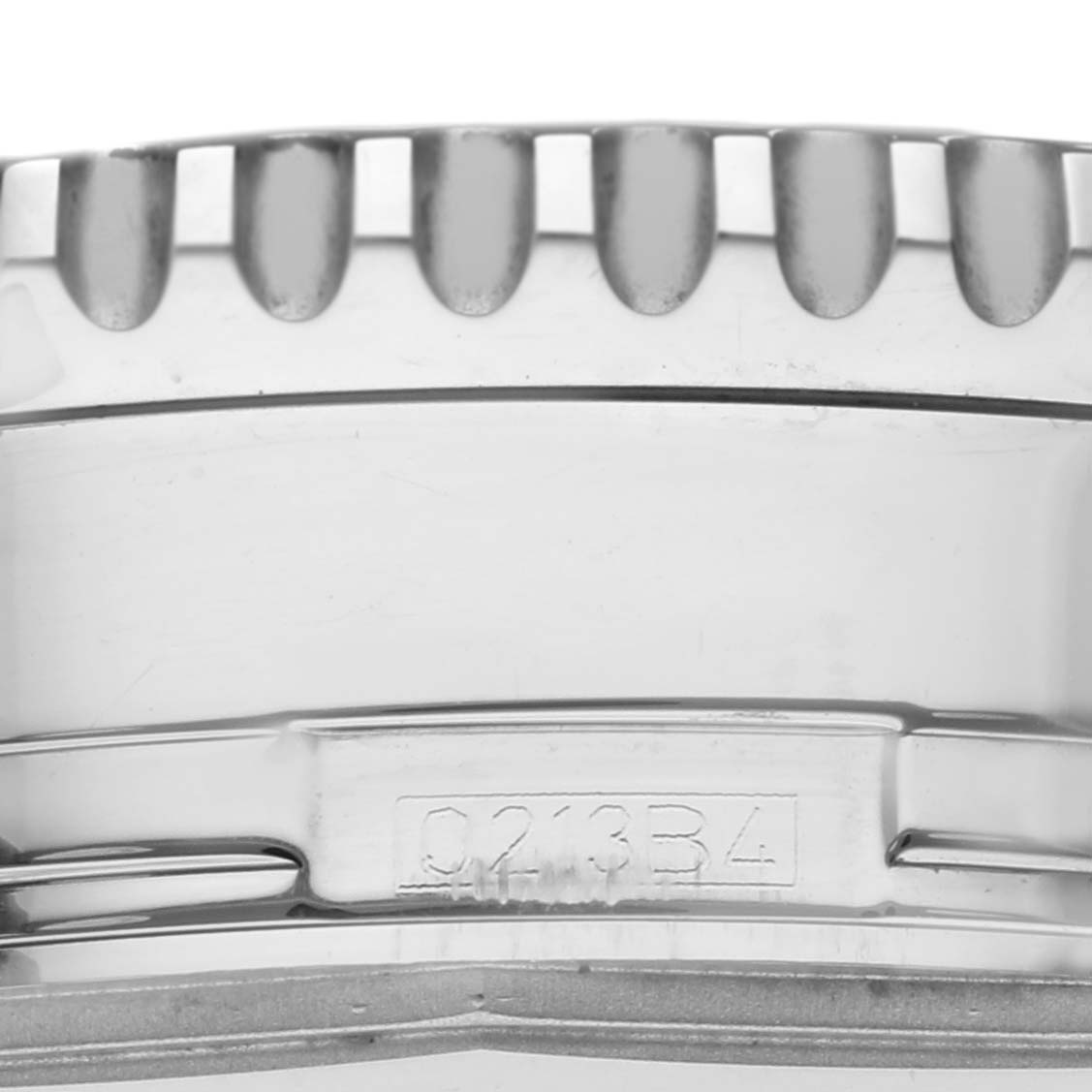 This close-up image of the Breitling Navitimer A2432212/G571 Men's Stainless Steel White Dial A2432212/G571 Men's Stainless Steel White Dial watch shows the bezel with its ridged edges and part of the case with an engraved serial number.