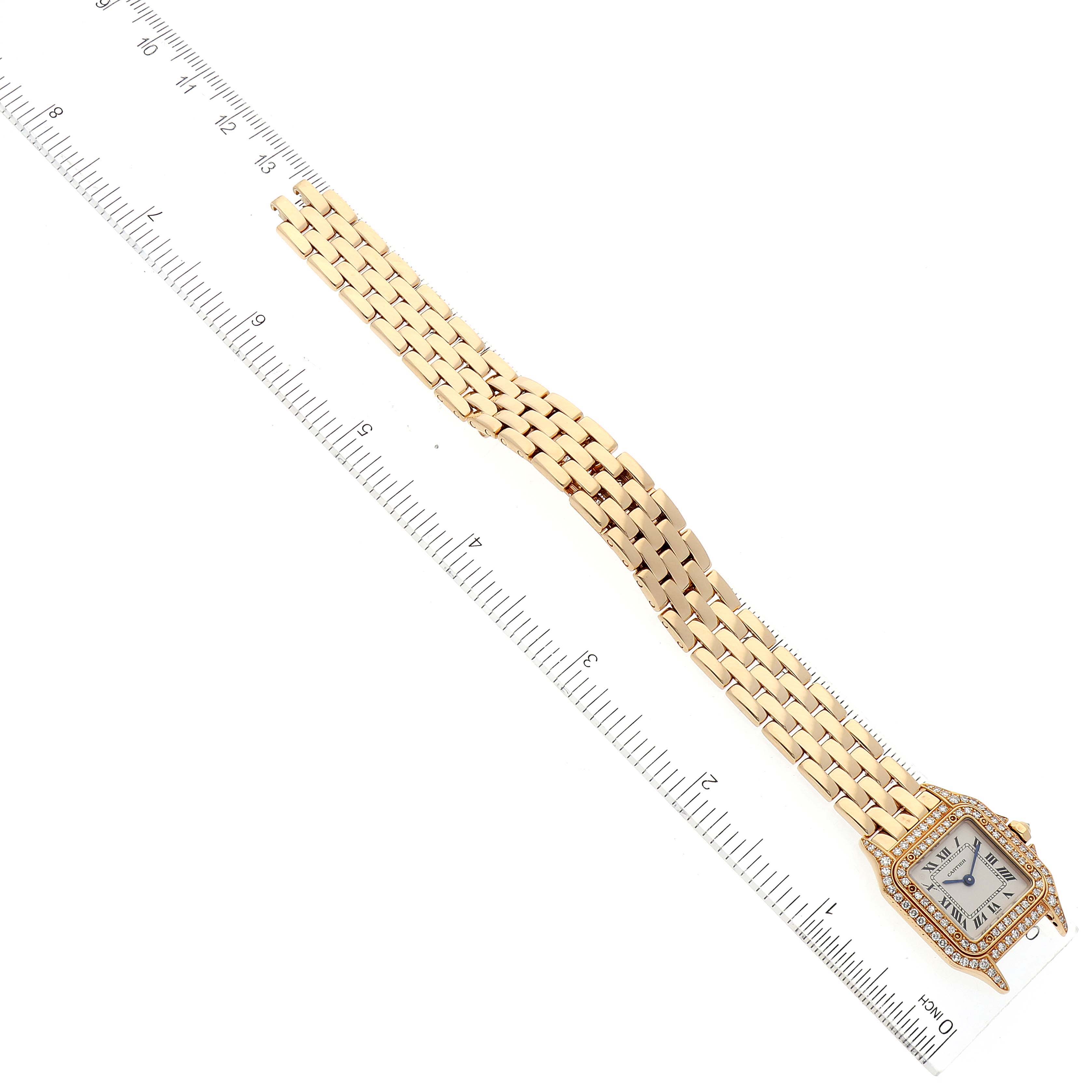 This image shows the Panthère model by Cartier from a top-down angle, highlighting its face, bezel, and bracelet next to a ruler.
