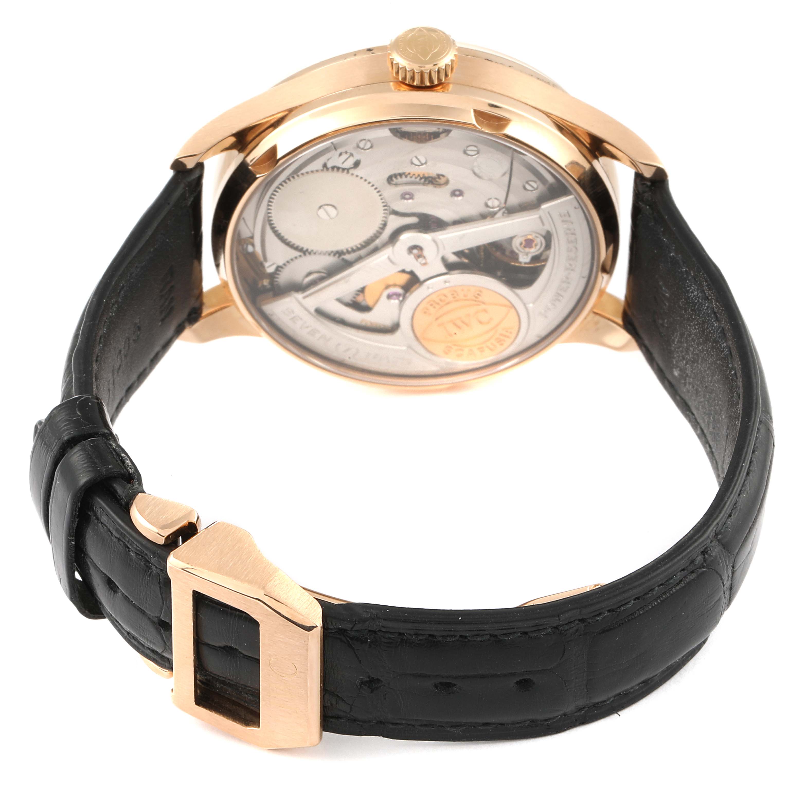 This image shows the back of the IWC Portuguese IW500004 Men's Rose Gold Silver Dial IW500004 Men's Rose Gold Silver Dial watch, highlighting its intricate mechanical movement and black leather strap.