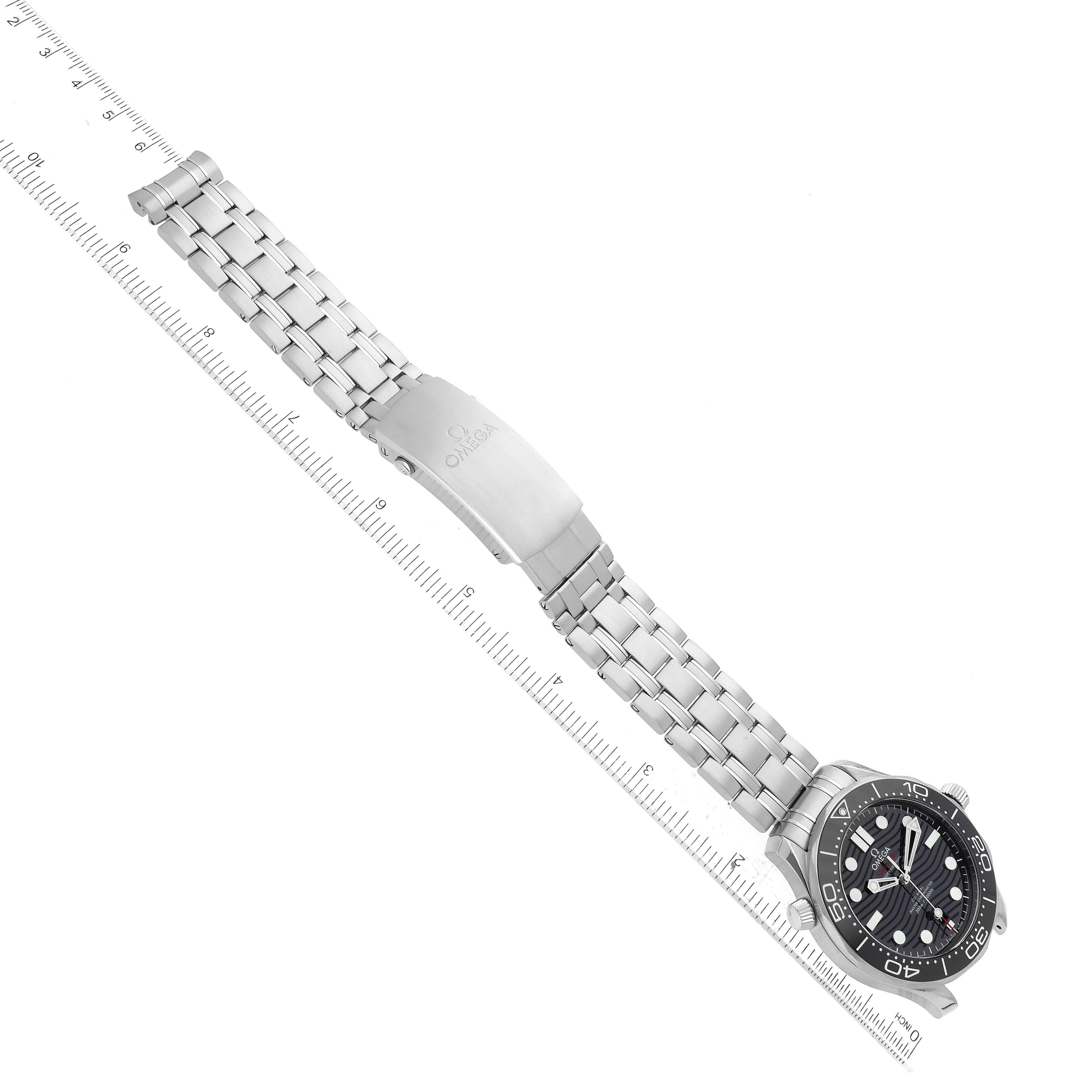 The image shows an Omega Seamaster 210.30.42.20.01.001 Men
s Stainless Steel Black Dial 210.30.42.20.01.001 Men
s Stainless Steel Black Dial watch at an angle displaying the full metal bracelet and watch face, resting diagonally on a ruler.