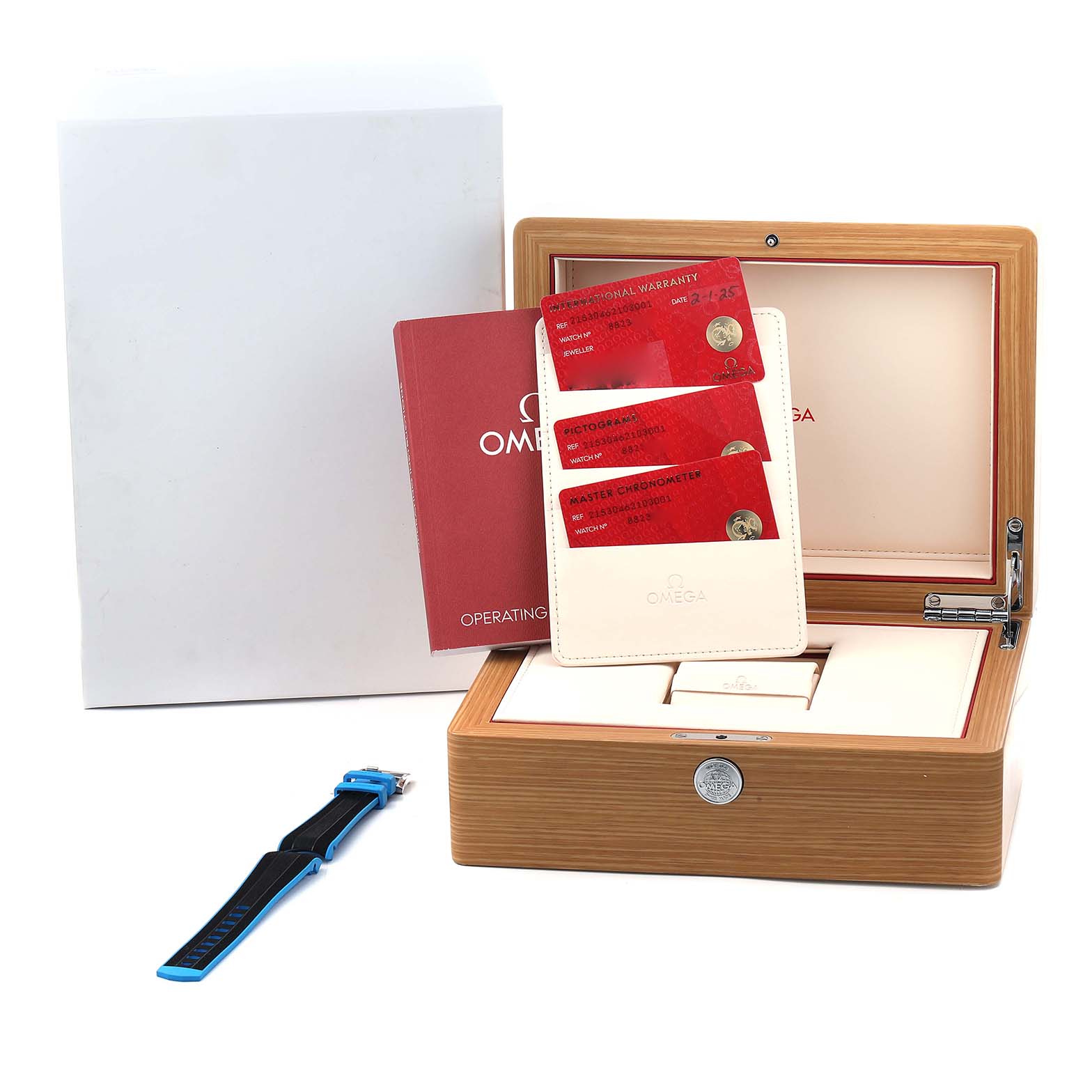 The image shows an Omega Planet Ocean 215.30.46.21.03.001 Men
s Stainless Steel Blue Dial watch box at an angle, with warranty cards, a manual, and a strap accessory.