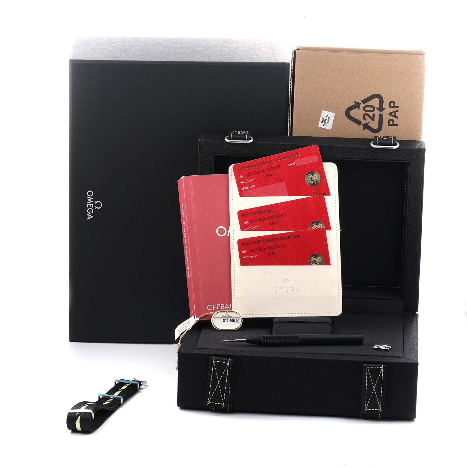 The image shows Omega Speedmaster 329.30.44.51.01.003 Men
s Stainless Steel Black Dial accessories, including a box, manuals, cards, a strap, and a tool, all from a front angle.