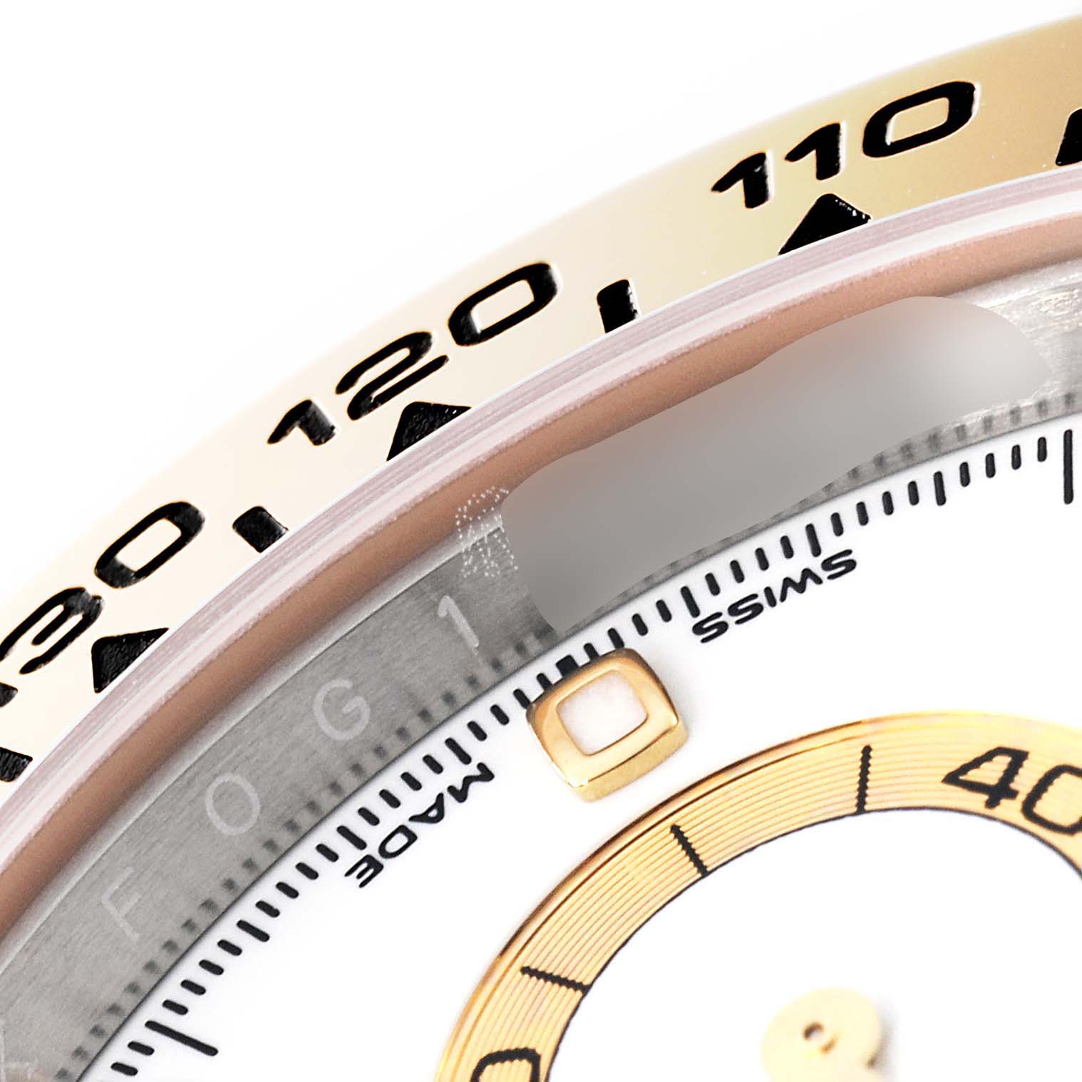 This close-up image shows part of the bezel and dial of a Rolex Daytona 116503 Men
s Steel and Gold (two tone) White Dial 116503 Men
s Steel and Gold (two tone) White Dial watch.