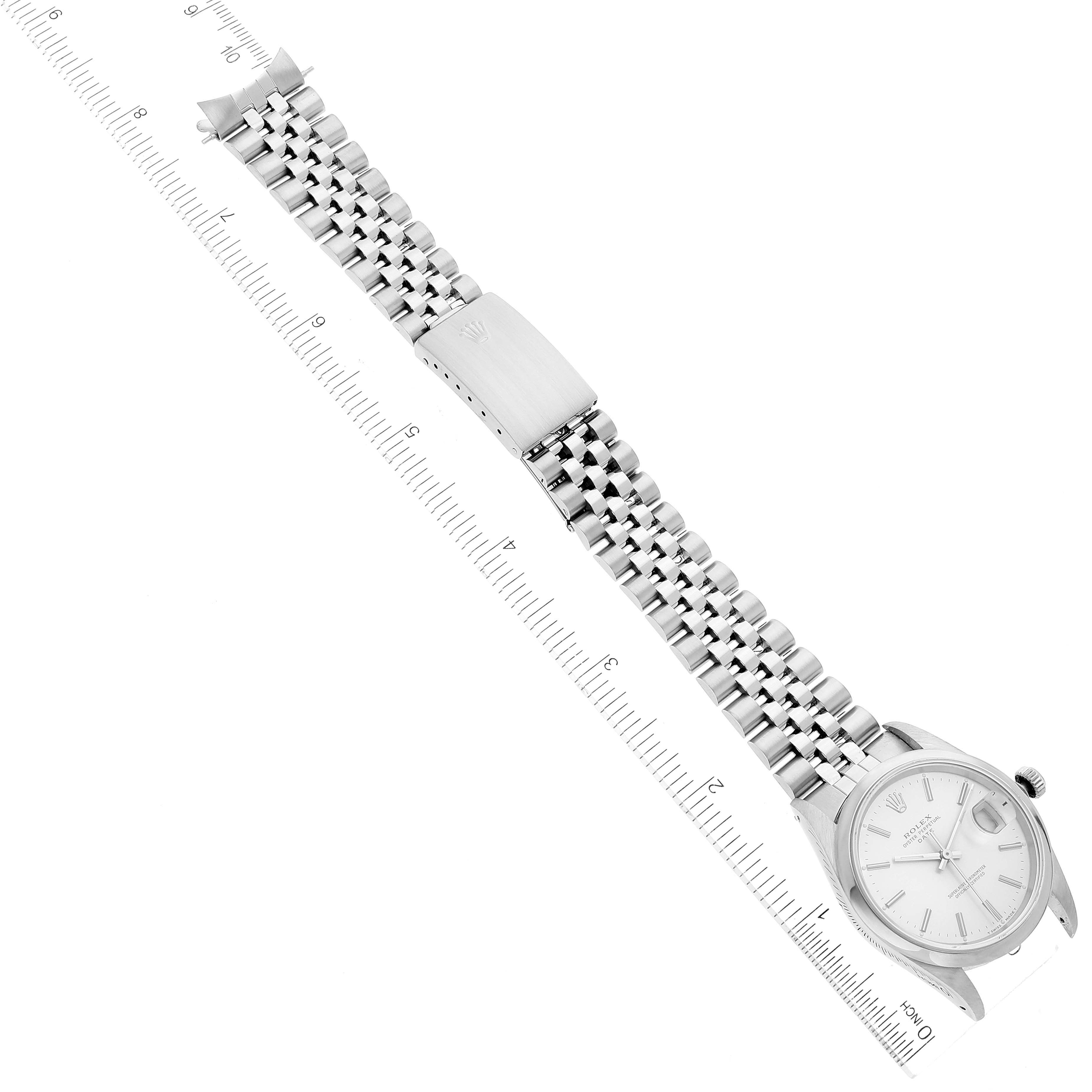 The image shows a top view of a Rolex Date 15200 Men's Stainless Steel Silver Dial 15200 Men's Stainless Steel Silver Dial watch with its bracelet fully extended alongside a ruler for scale.