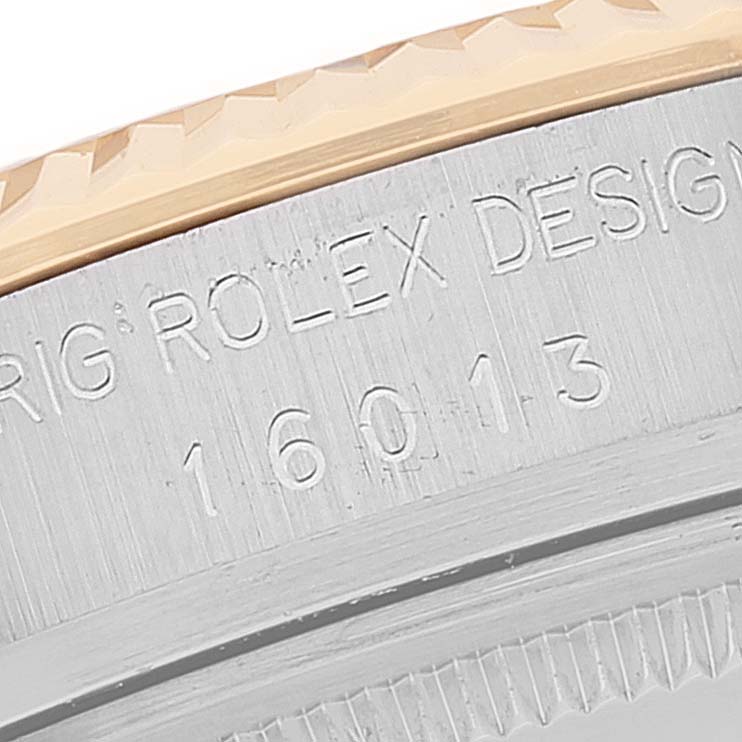 This close-up image shows the serial number engraving and part of the fluted bezel of a Rolex Datejust 16013 Men
s Steel and Gold (two tone) Champagne Dial 16013 Men
s Steel and Gold (two tone) Champagne Dial watch.