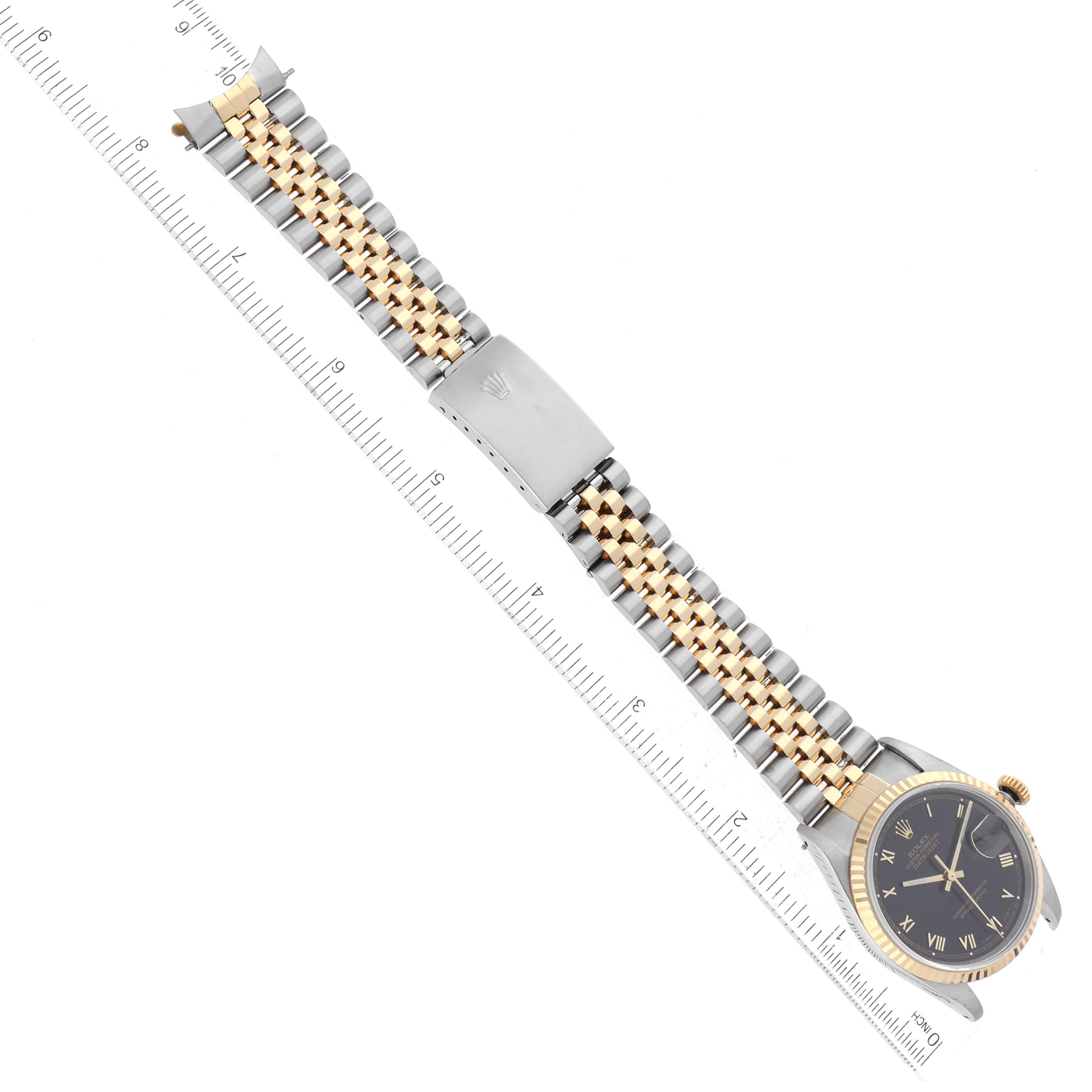 This image shows a Rolex Datejust 16233 Men's Steel and Gold (two tone) Black Dial 16233 Men's Steel and Gold (two tone) Black Dial watch from a top-down angle, highlighting its jubilee bracelet, clasp, and face with Roman numerals.