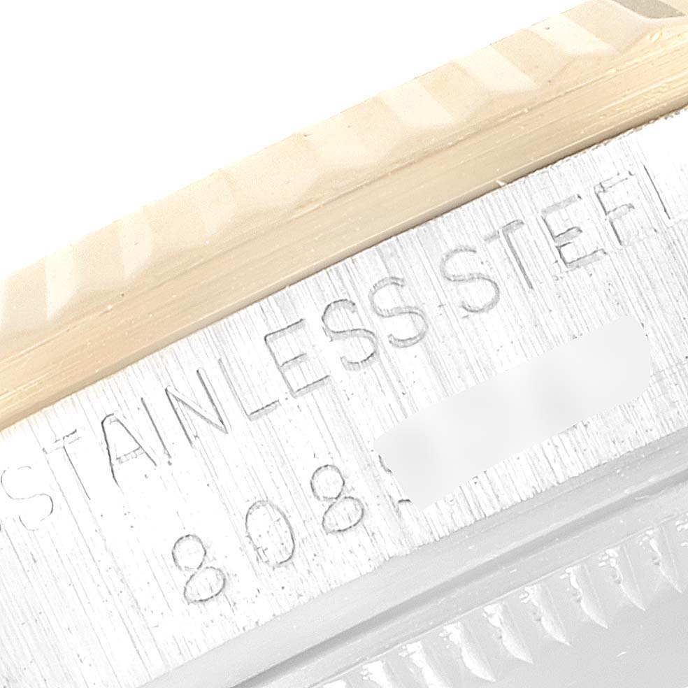 The image shows a close-up of the stainless steel frame and part of the bezel of the Mid-Size Rolex watch.