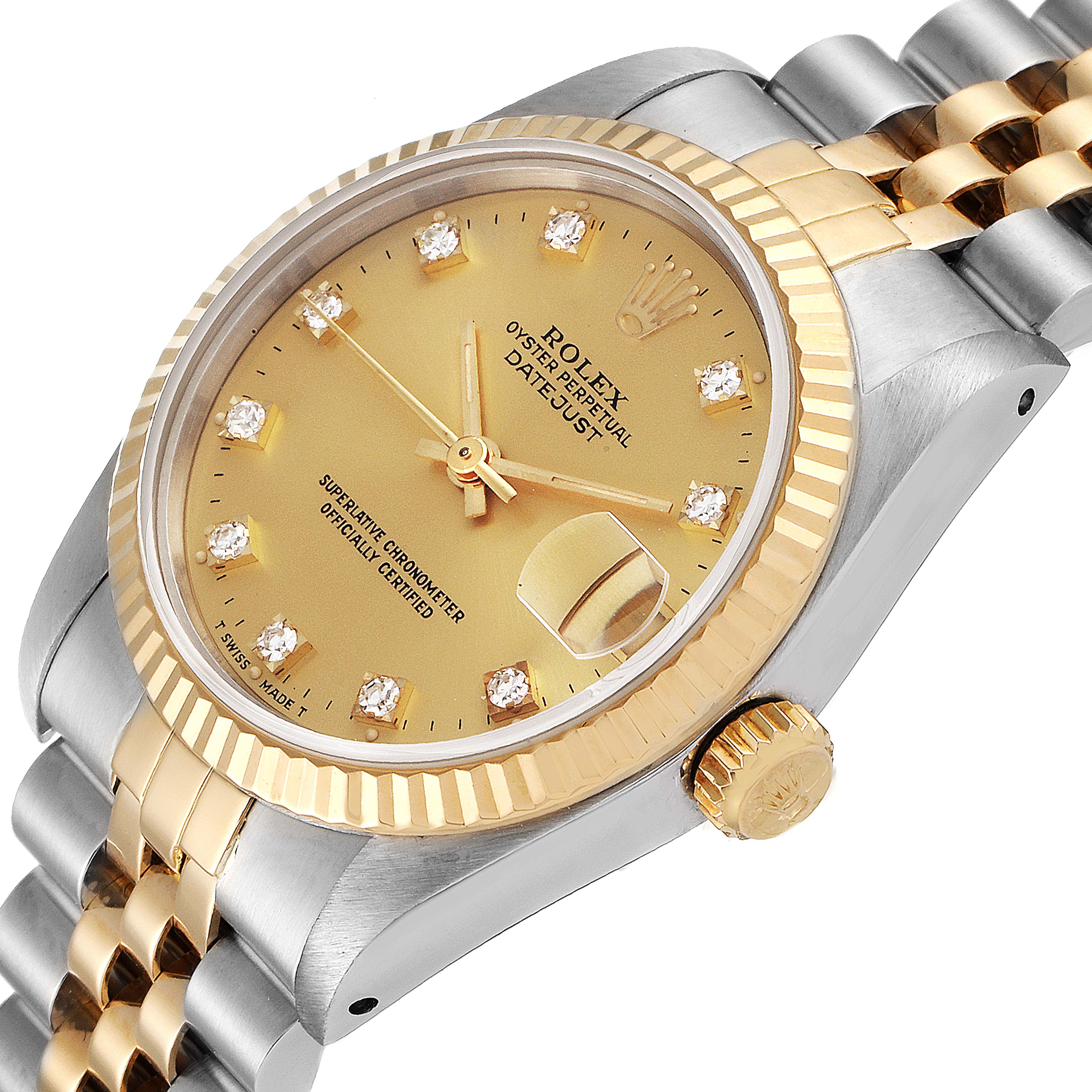 The image shows a mid-size Rolex Oyster Perpetual Datejust watch at an angled view, highlighting its gold-tone dial, fluted bezel, and bimetal Jubilee bracelet.