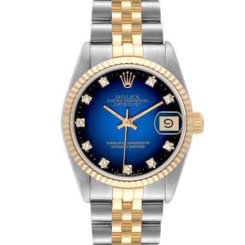 The image shows a front view of the Rolex Mid-Size Datejust, featuring a blue dial, gold and silver bracelet, and diamond hour markers.