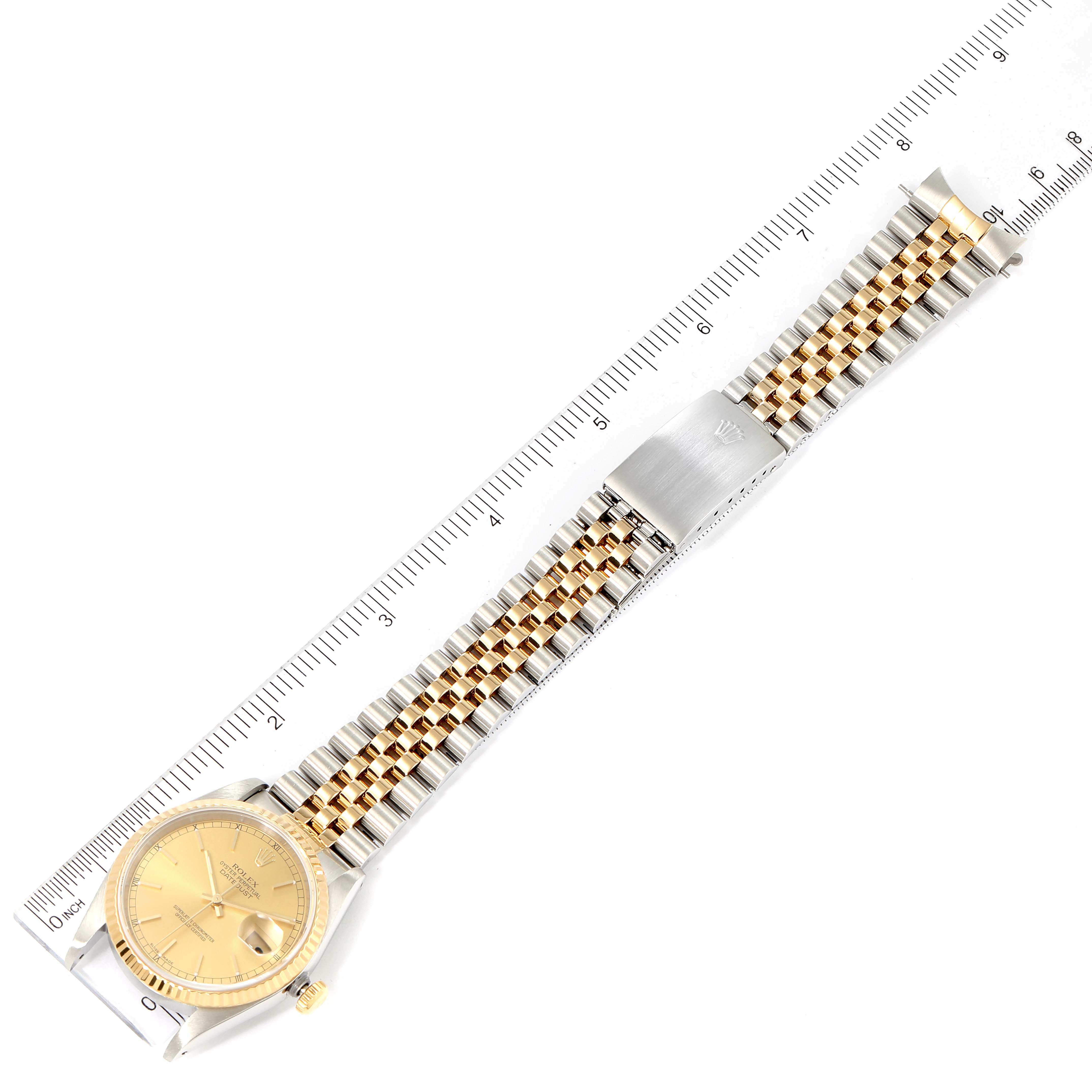 The image shows a flat lay of a Rolex Datejust 16233 Men's Steel and Gold (two tone) Champagne Dial 16233 Men's Steel and Gold (two tone) Champagne Dial watch, highlighting the dial, bracelet, and clasp alongside a ruler for scale.