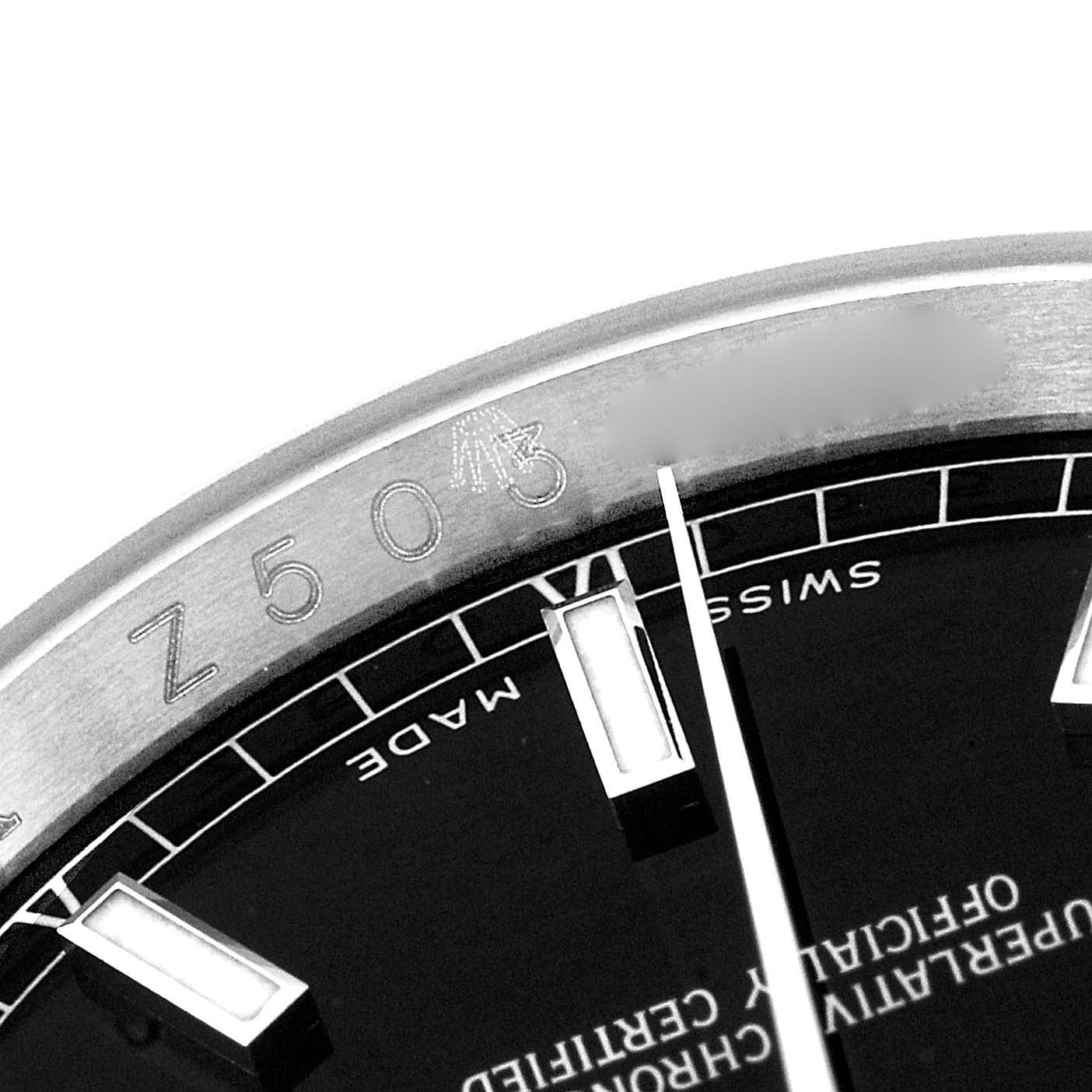 This close-up shot of a Rolex Datejust 116234 Men's Stainless Steel Black Dial 116234 Men's Stainless Steel Black Dial watch shows the dial, hour markers, and part of the rehaut (inner bezel) with engravings.