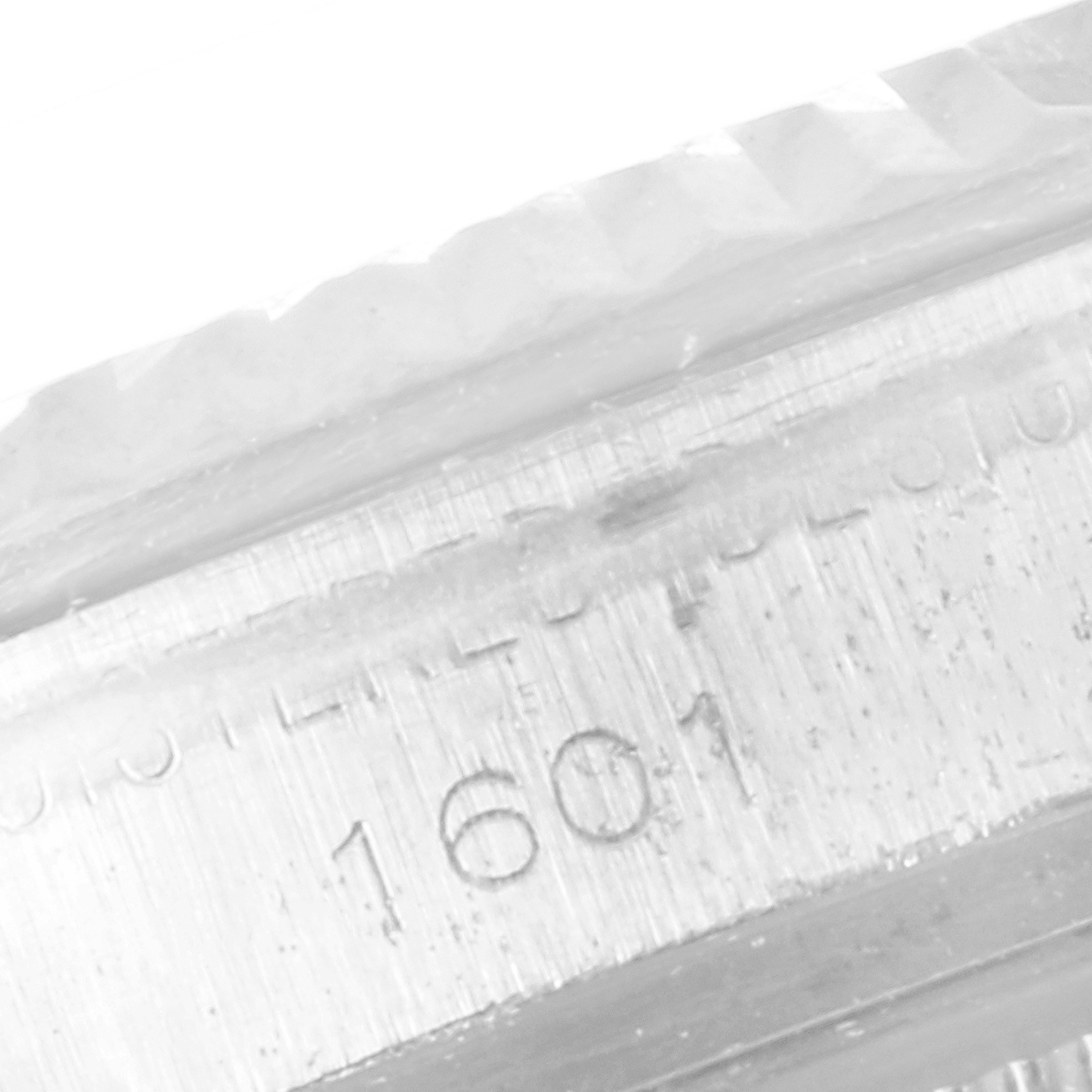 This close-up photo shows the model number and part of the bezel of the Rolex Vintage Collection 1601 Men's Stainless Steel Silver Dial 1601 Men's Stainless Steel Silver Dial watch.