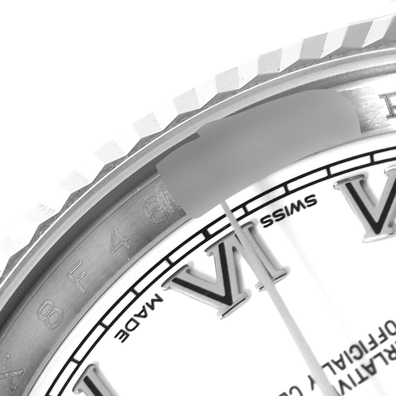 This close-up image of a Rolex Datejust 116234 Men's Stainless Steel White Dial 116234 Men's Stainless Steel White Dial watch shows the fluted bezel, part of the dial, and Roman numeral hour markers.