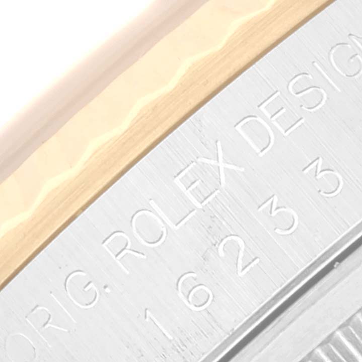 This close-up image shows the engraved side of the bezel and case of a Rolex Datejust 16233 Men's Steel and Gold (two tone) Beige Dial 16233 Men's Steel and Gold (two tone) Beige Dial watch.