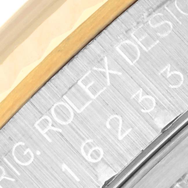 A close-up view of the Rolex Datejust 16233 Men's Steel and Gold (two tone) Black Dial 16233 Men's Steel and Gold (two tone) Black Dial watch showing part of the bezel and engraved details on the edge.