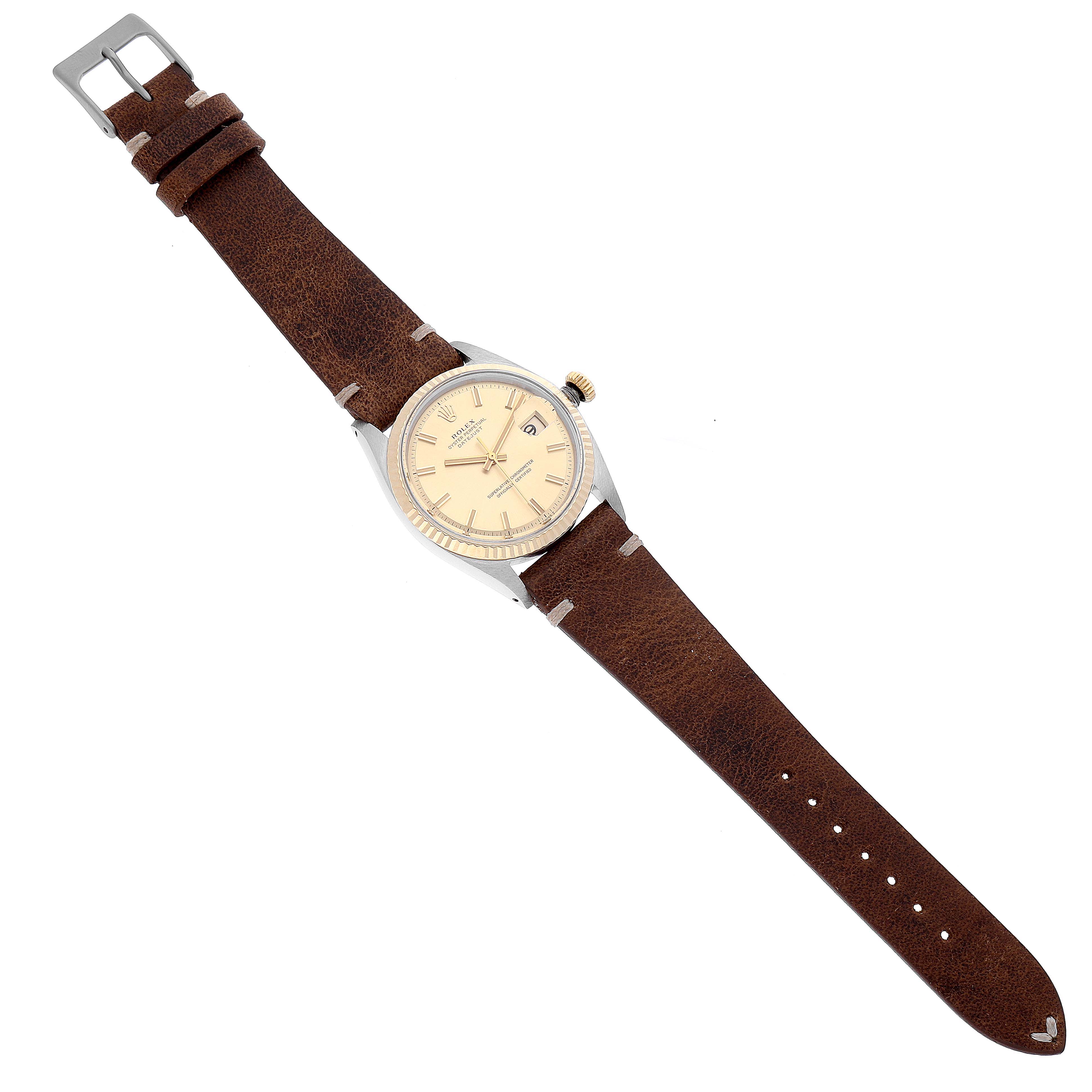 The Rolex Datejust 1601 Men's Steel and Gold (two tone) Champagne Dial 1601 Men's Steel and Gold (two tone) Champagne Dial watch is shown from a top view, featuring its round face, bezel, crown, leather strap, and buckle.