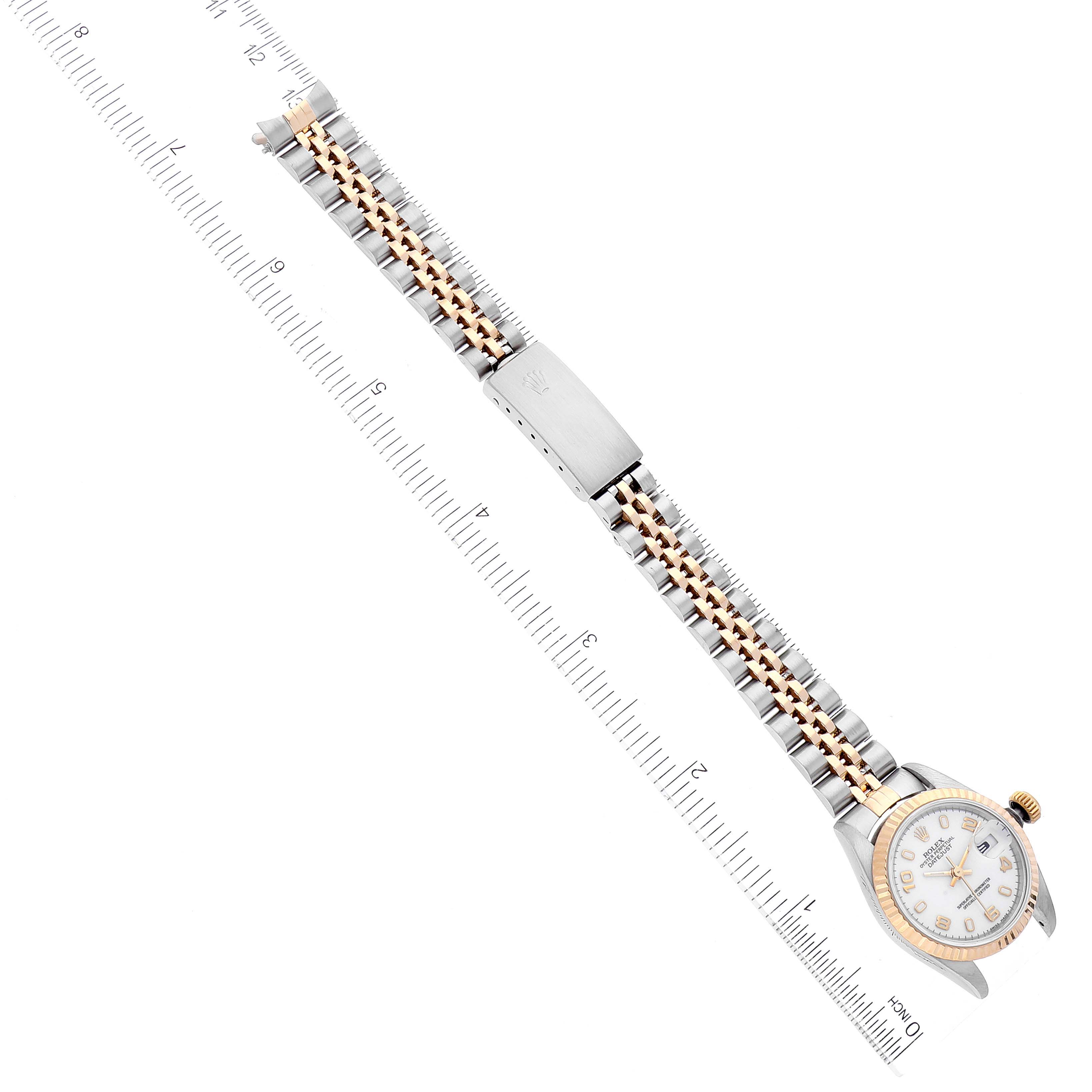 The image shows a top-down view of the Rolex Datejust 69173 Women
s Steel and Gold (two tone) White Dial 69173 Women
s Steel and Gold (two tone) White Dial watch, highlighting its band, clasp, and face alongside a measurement ruler.