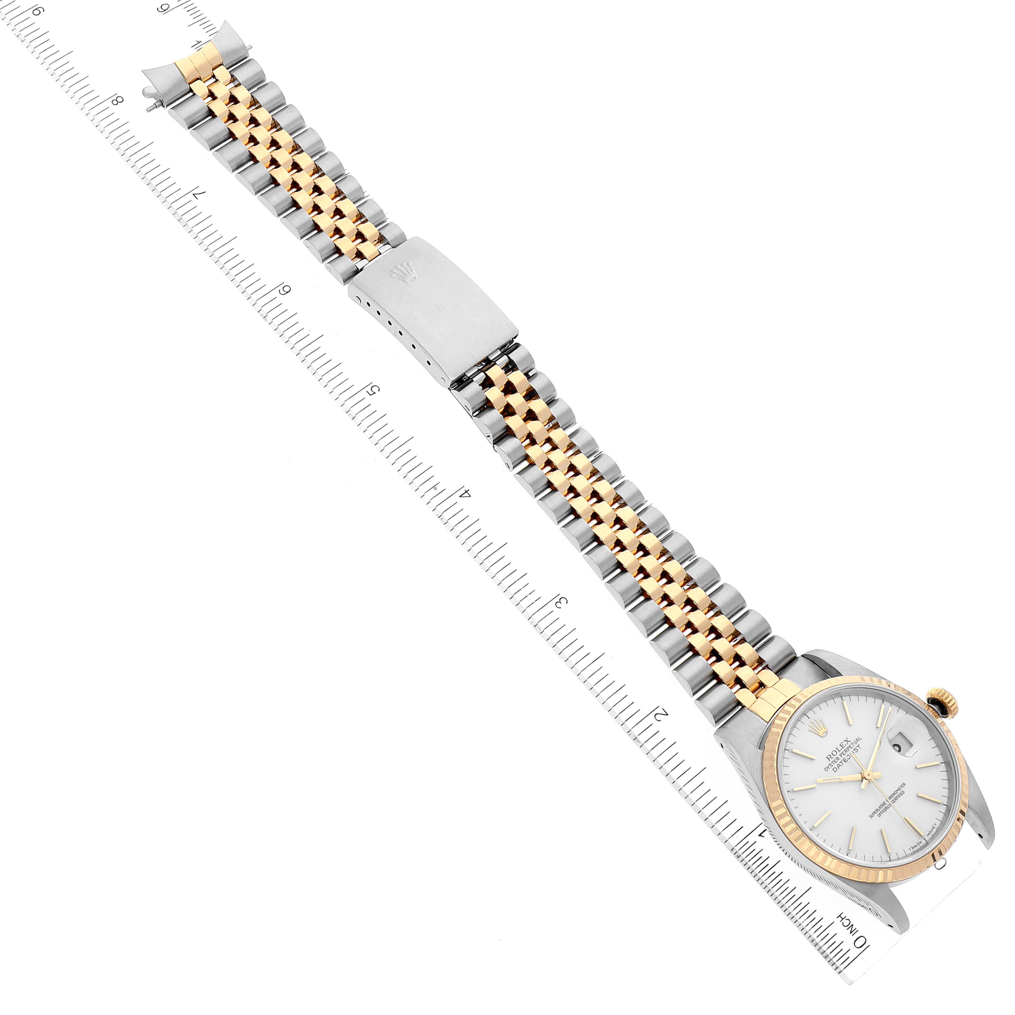 The image shows a Rolex Datejust 16233 Men's Steel and Gold (two tone) White Dial 16233 Men's Steel and Gold (two tone) White Dial watch laying flat with its dial, bracelet, and clasp visible, alongside a measurement ruler.