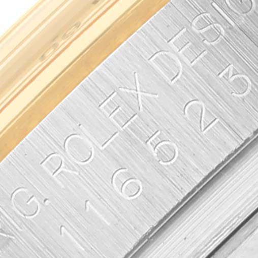 This close-up shows the engraved bezel of a Rolex Daytona 116523 Men's Steel and Gold (two tone) White Dial 116523 Men's Steel and Gold (two tone) White Dial watch.