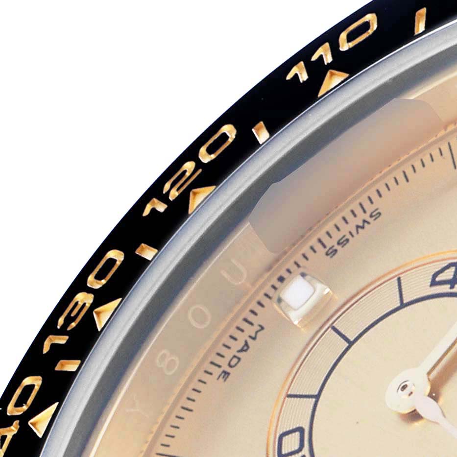 The image shows a close-up of the bezel and partial dial of a Rolex Daytona 116518LN Men
s Yellow Gold Champagne Dial, highlighting the tachymetric scale.
